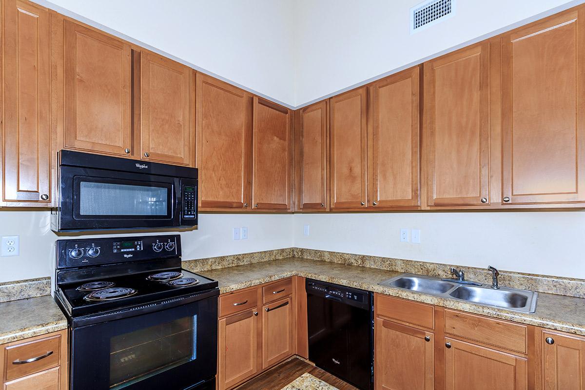 a kitchen with wooden cabinets and a black stove top oven