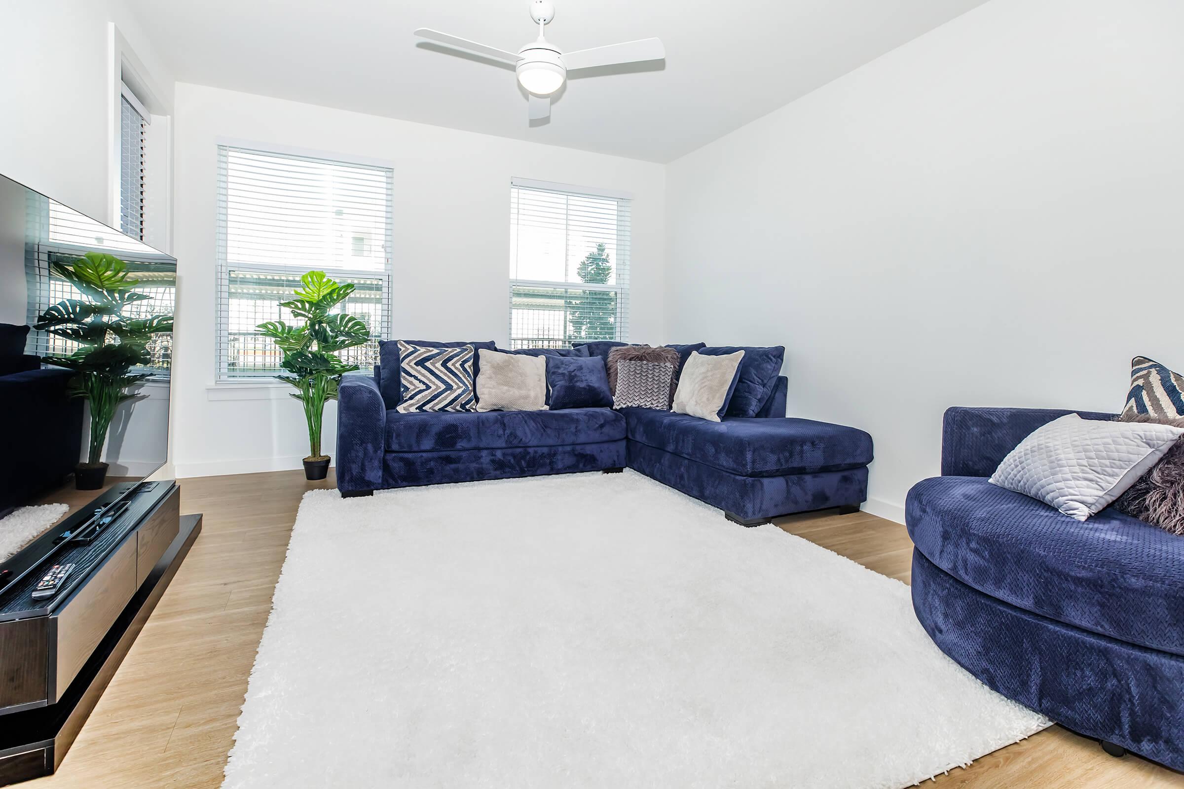 a living room filled with furniture and a large window