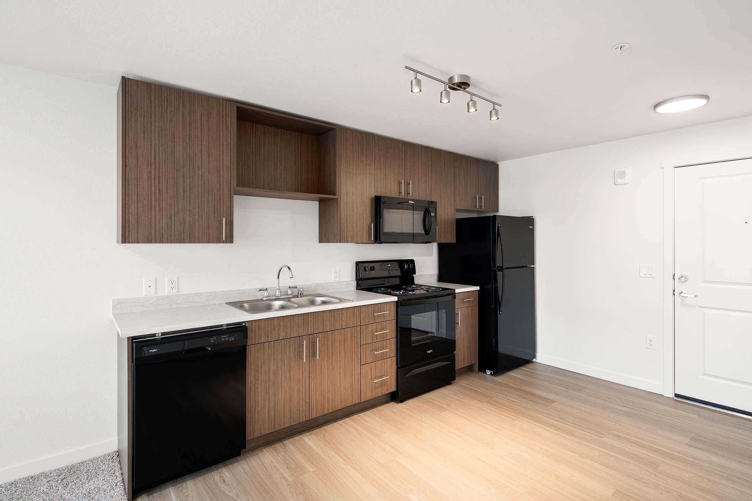 a large kitchen with stainless steel appliances and wooden cabinets