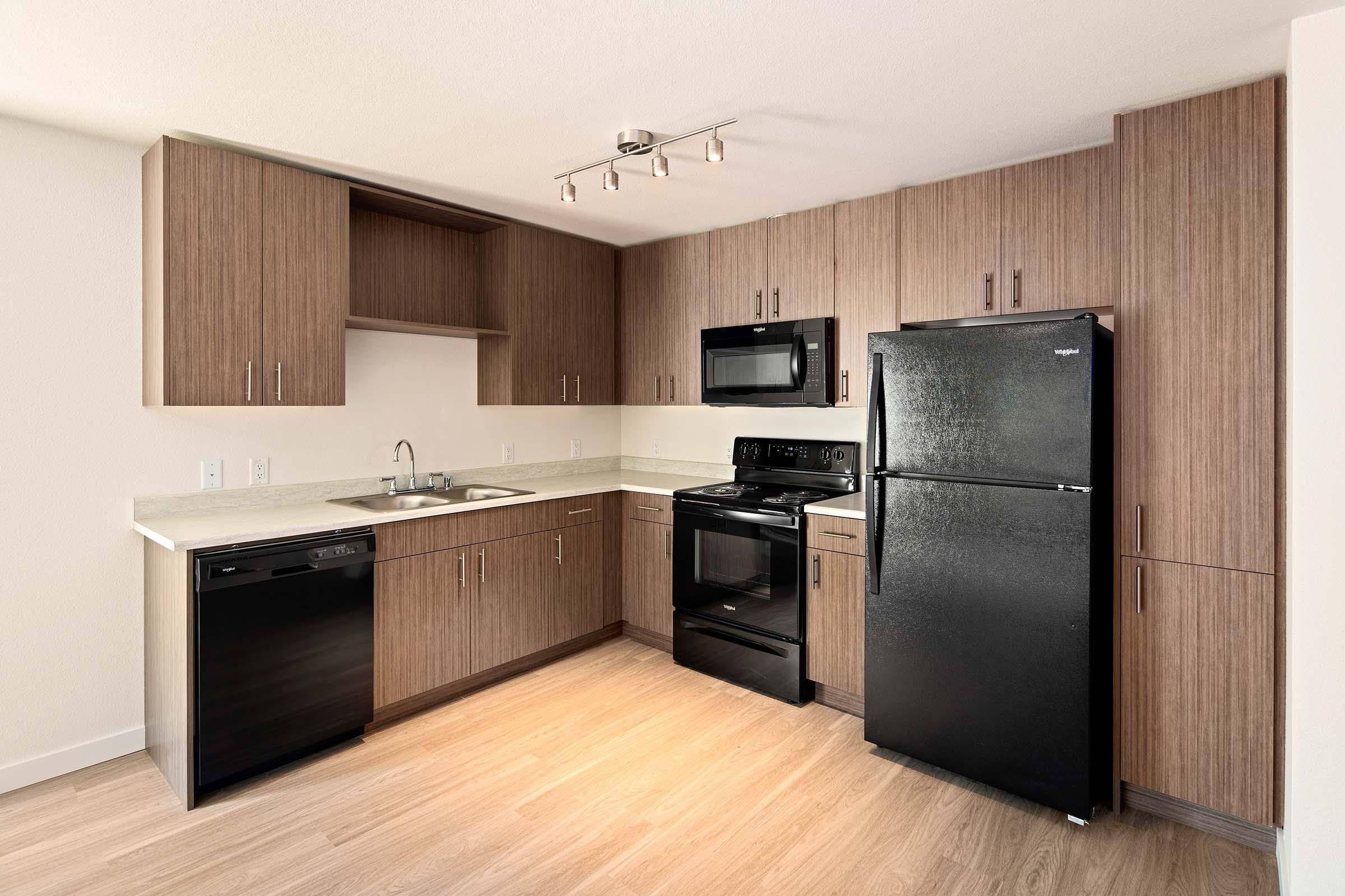 a large kitchen with stainless steel appliances and wooden cabinets