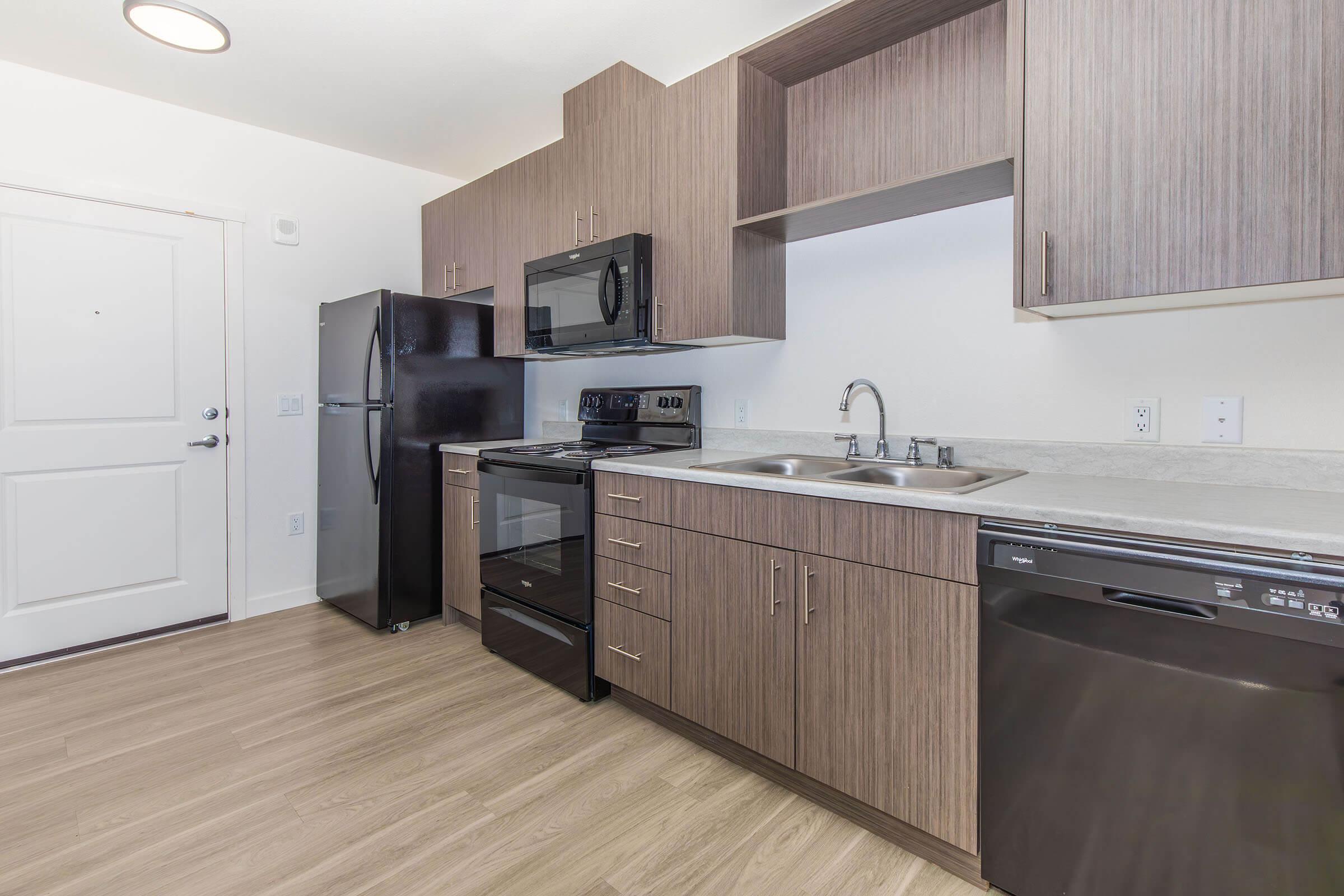 a large kitchen with stainless steel appliances and wooden cabinets