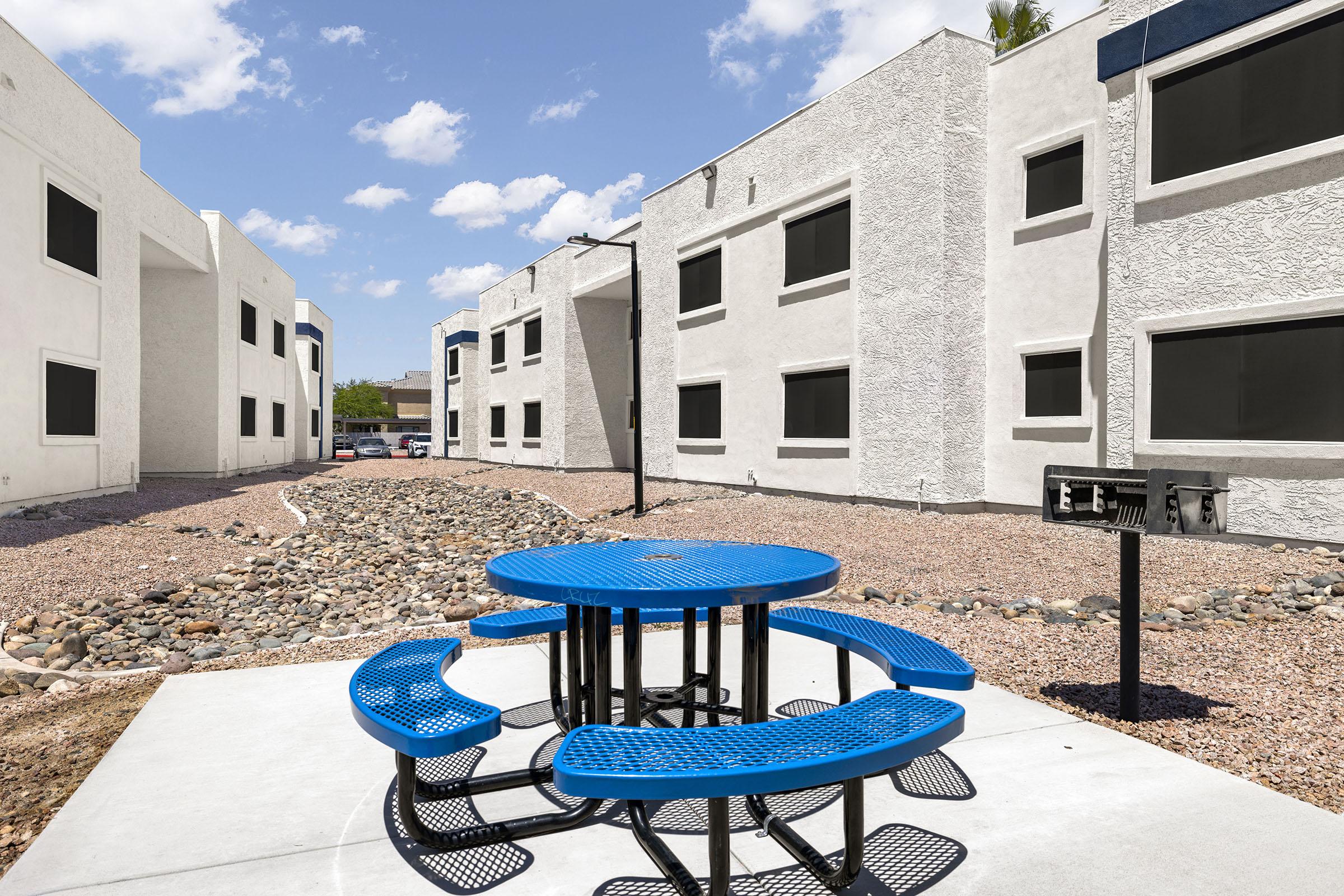 Outdoor picnic seating beside the apartment buildings.