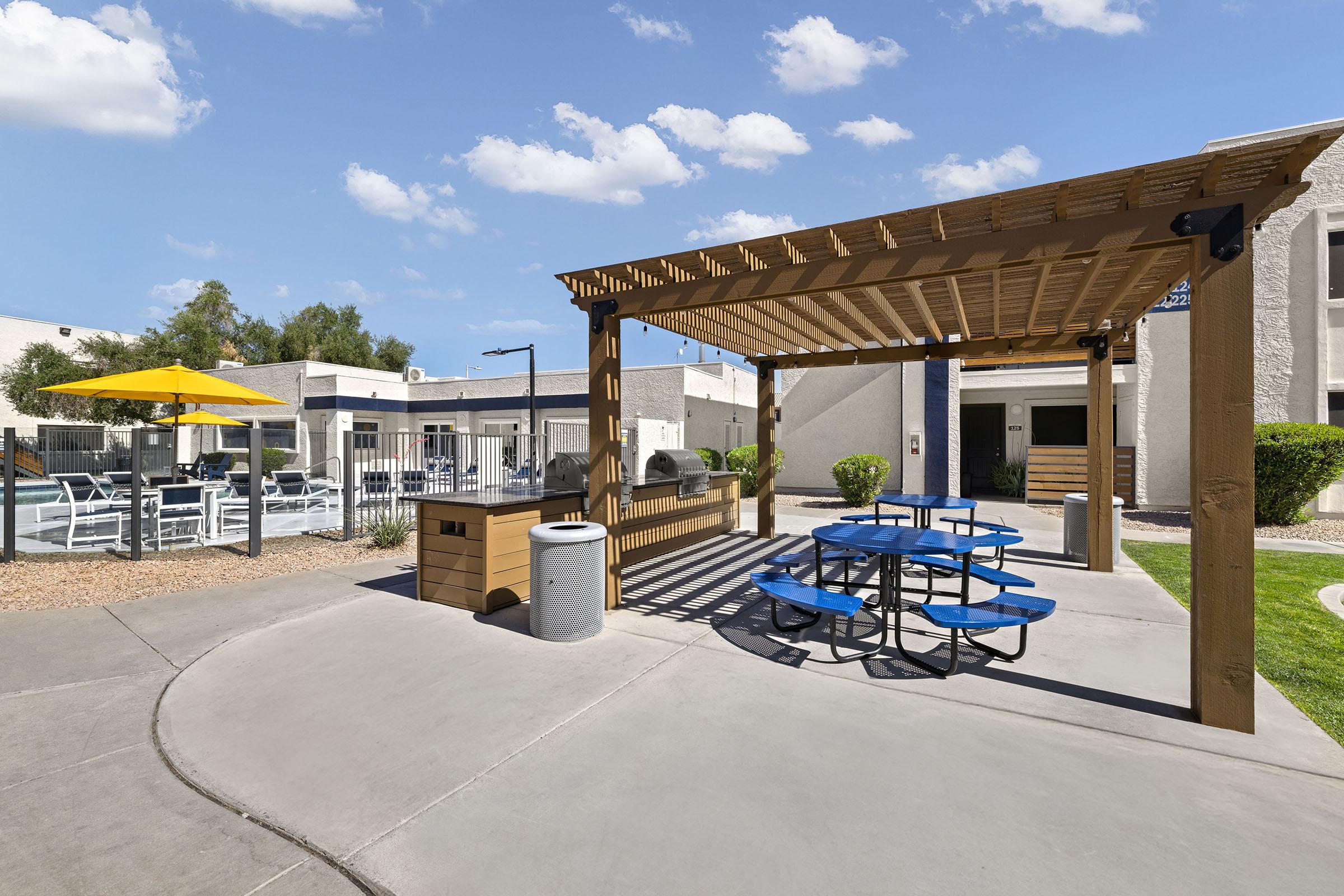Outdoor picnic seating beside the apartment buildings.