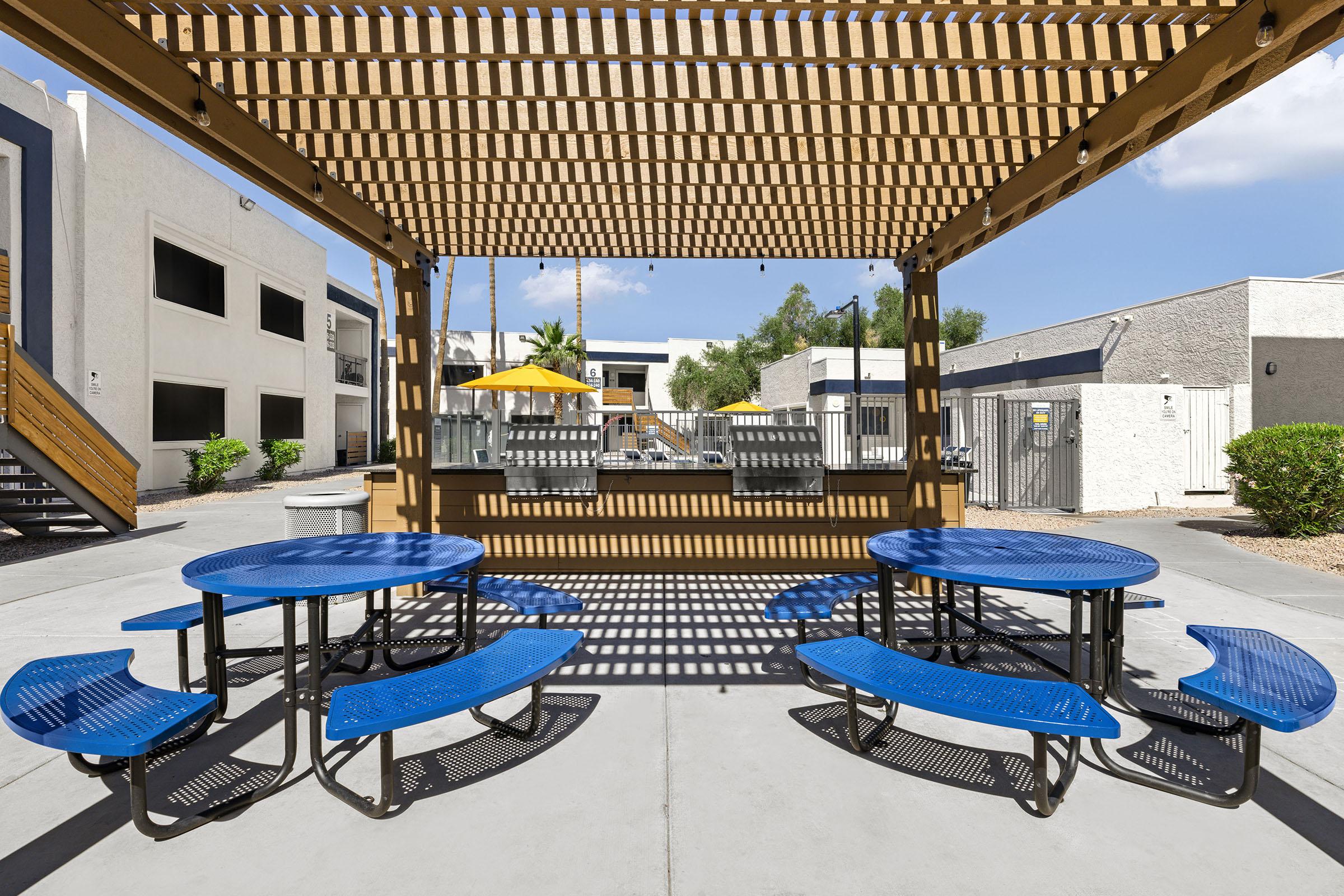 Outdoor picnic seating beside the apartment buildings.