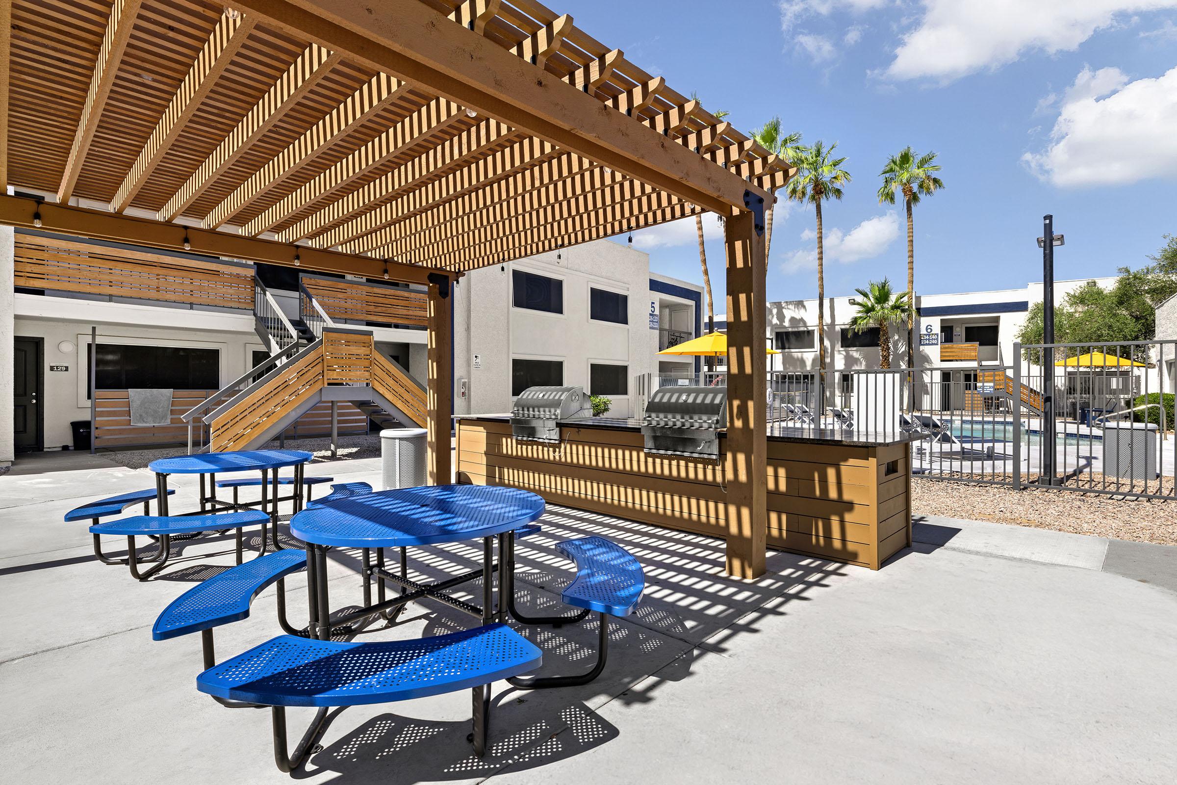 Outdoor picnic seating beside the apartment buildings.