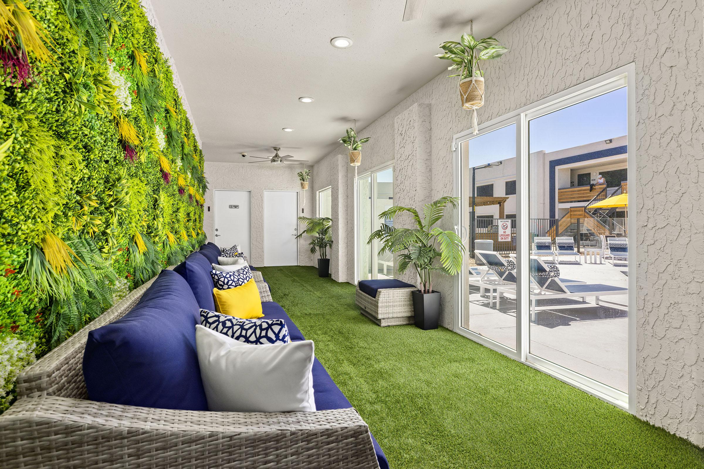 Indoor lounge with seating and a plant wall.