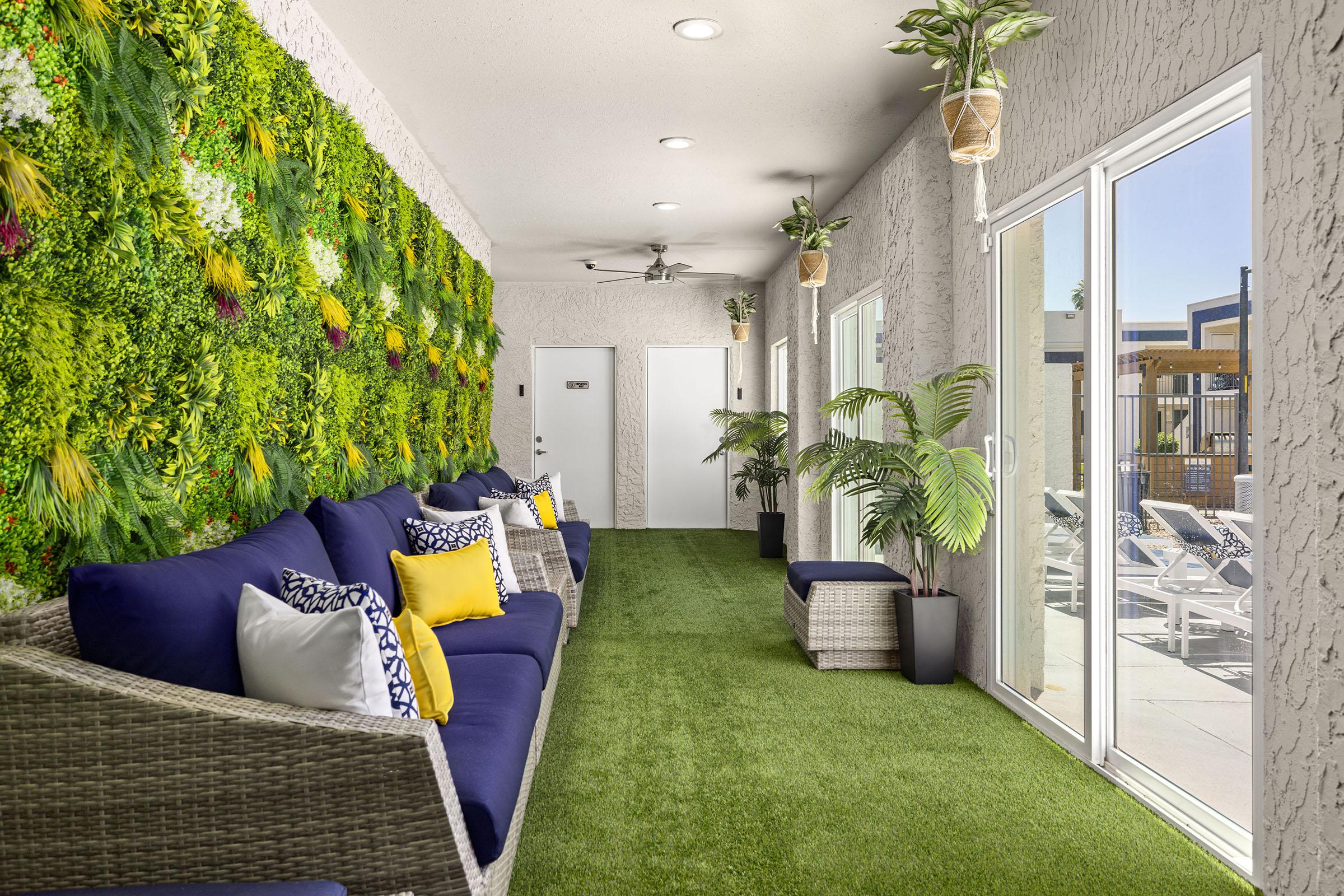 Indoor lounge with seating and a plant wall.