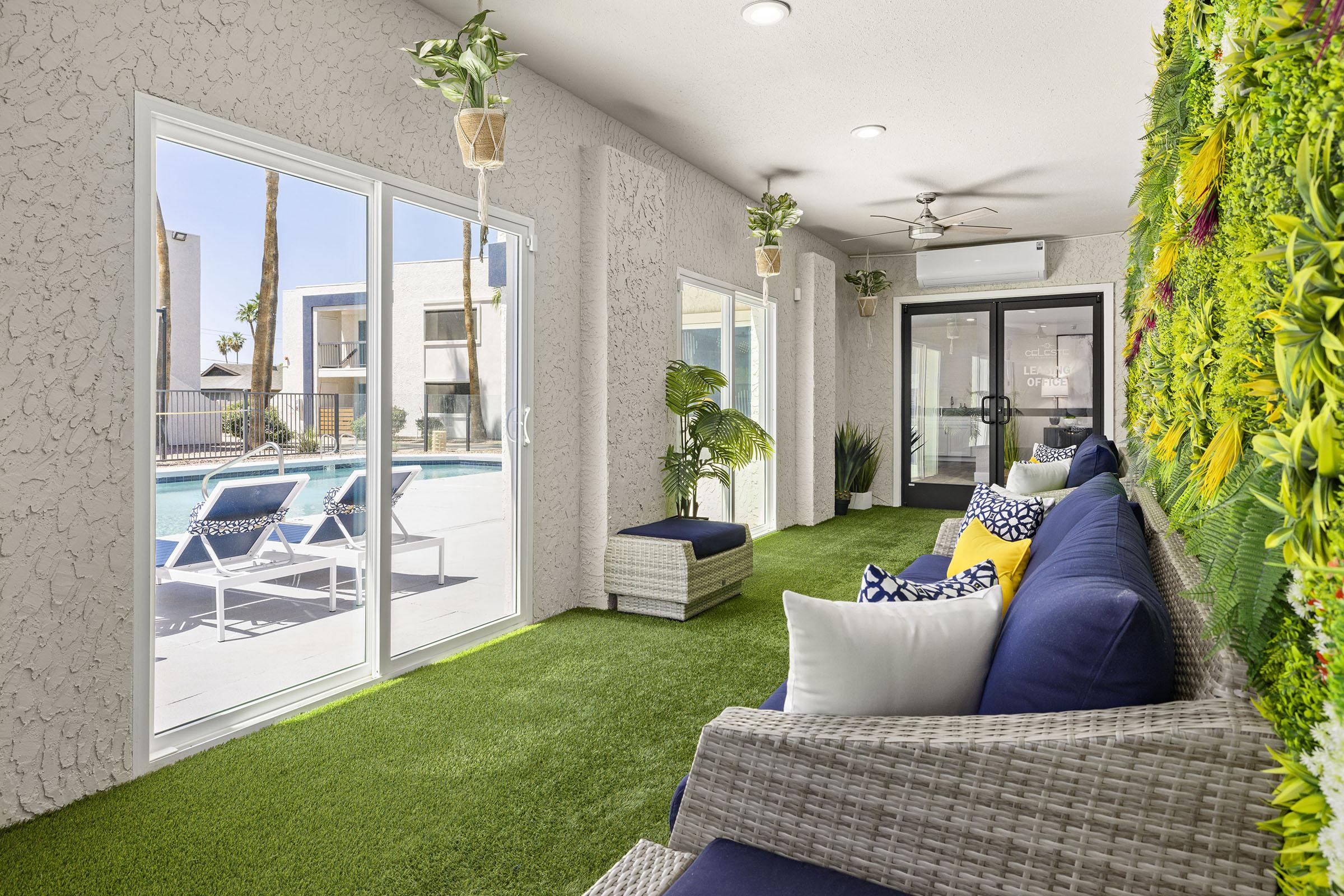 Indoor lounge with seating and a plant wall.