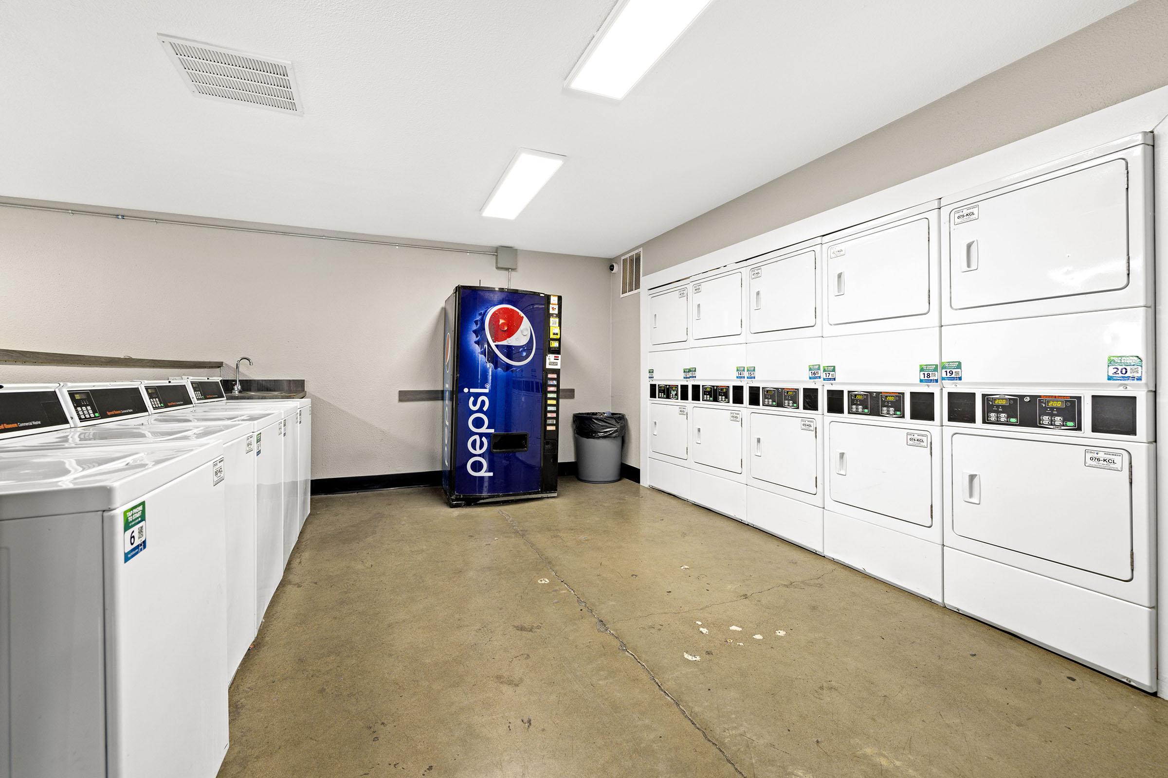 Shared laundry room with washers and dryers.