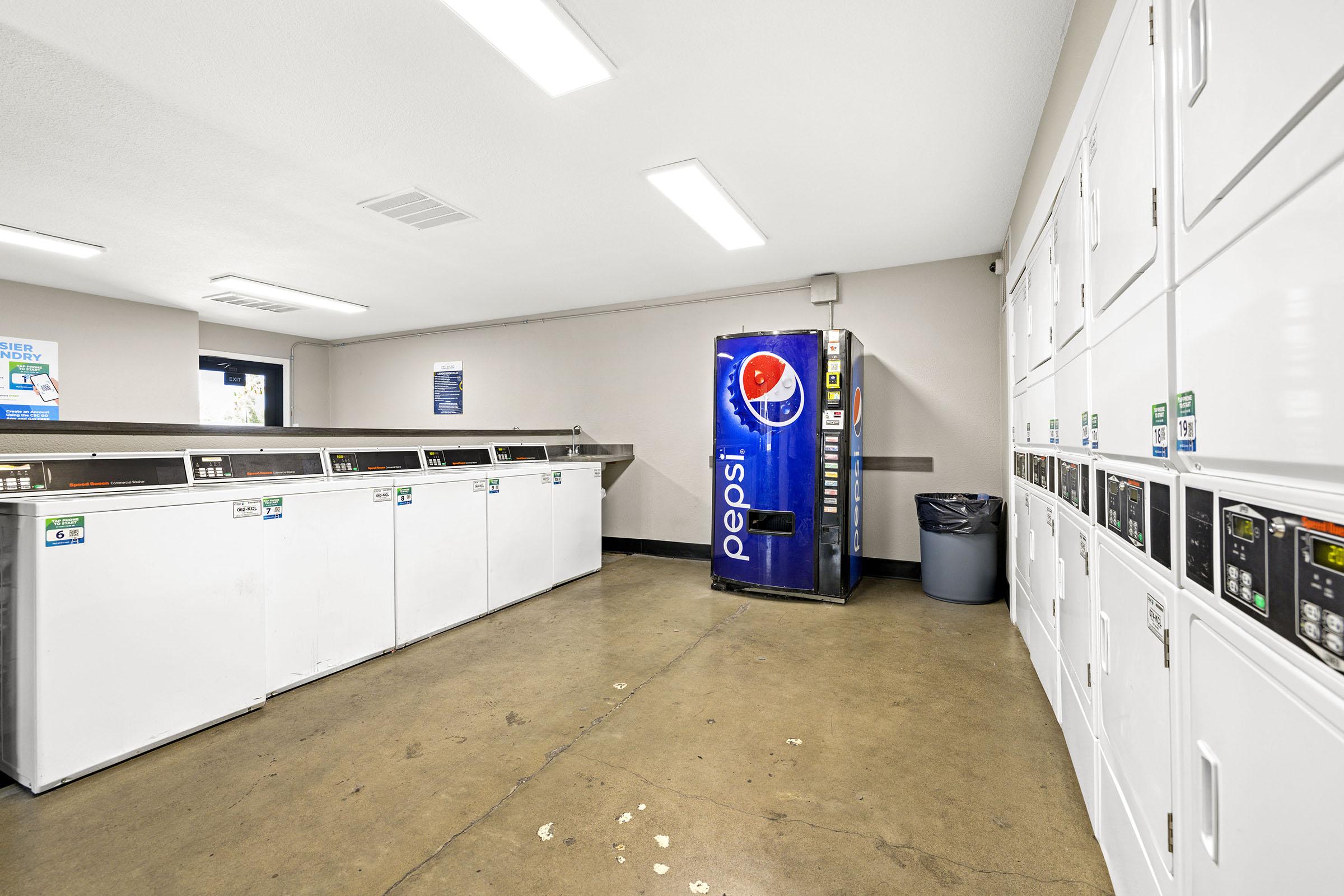 Shared laundry room with washers and dryers.