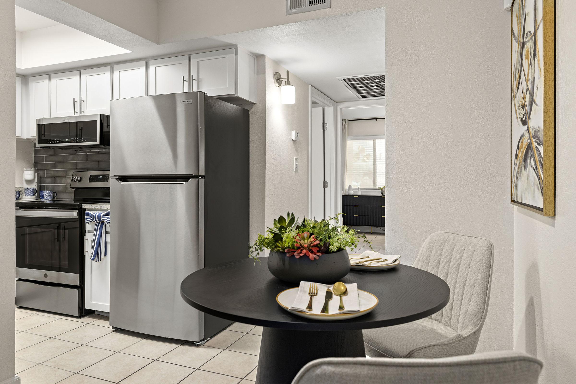Model apartment kitchen with white cabinets.