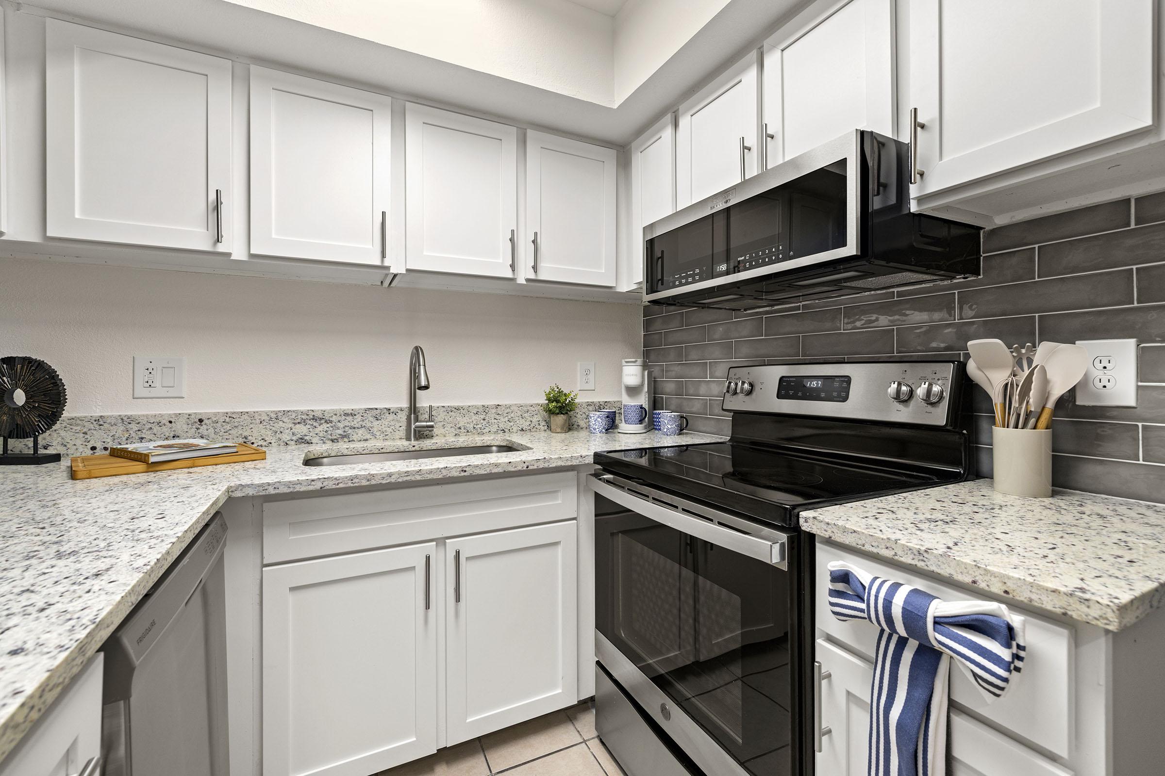 Model apartment kitchen with white cabinets.