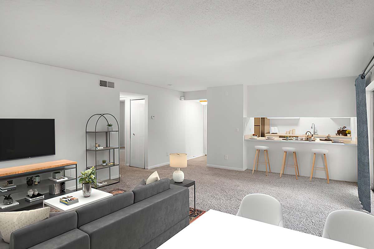 Cozy and modern living space featuring a gray sofa, a TV on a wooden stand, and a stylish shelf. The open layout connects the living area to a bright kitchen with bar stools. Soft lighting and neutral colors create a welcoming atmosphere, complemented by decorative plants and minimalist furnishings.