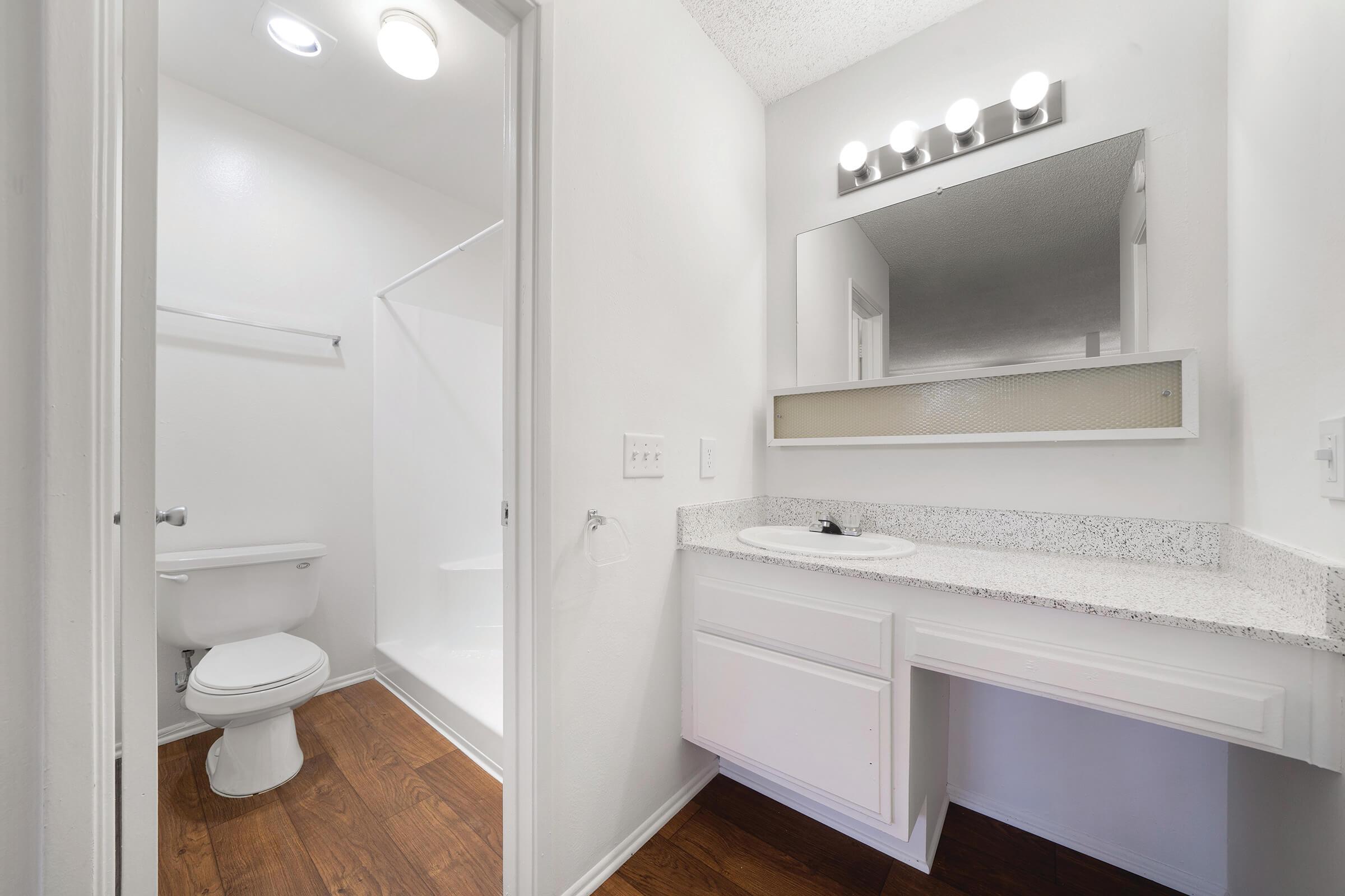 Bathroom sink and open bathroom door with wooden floors