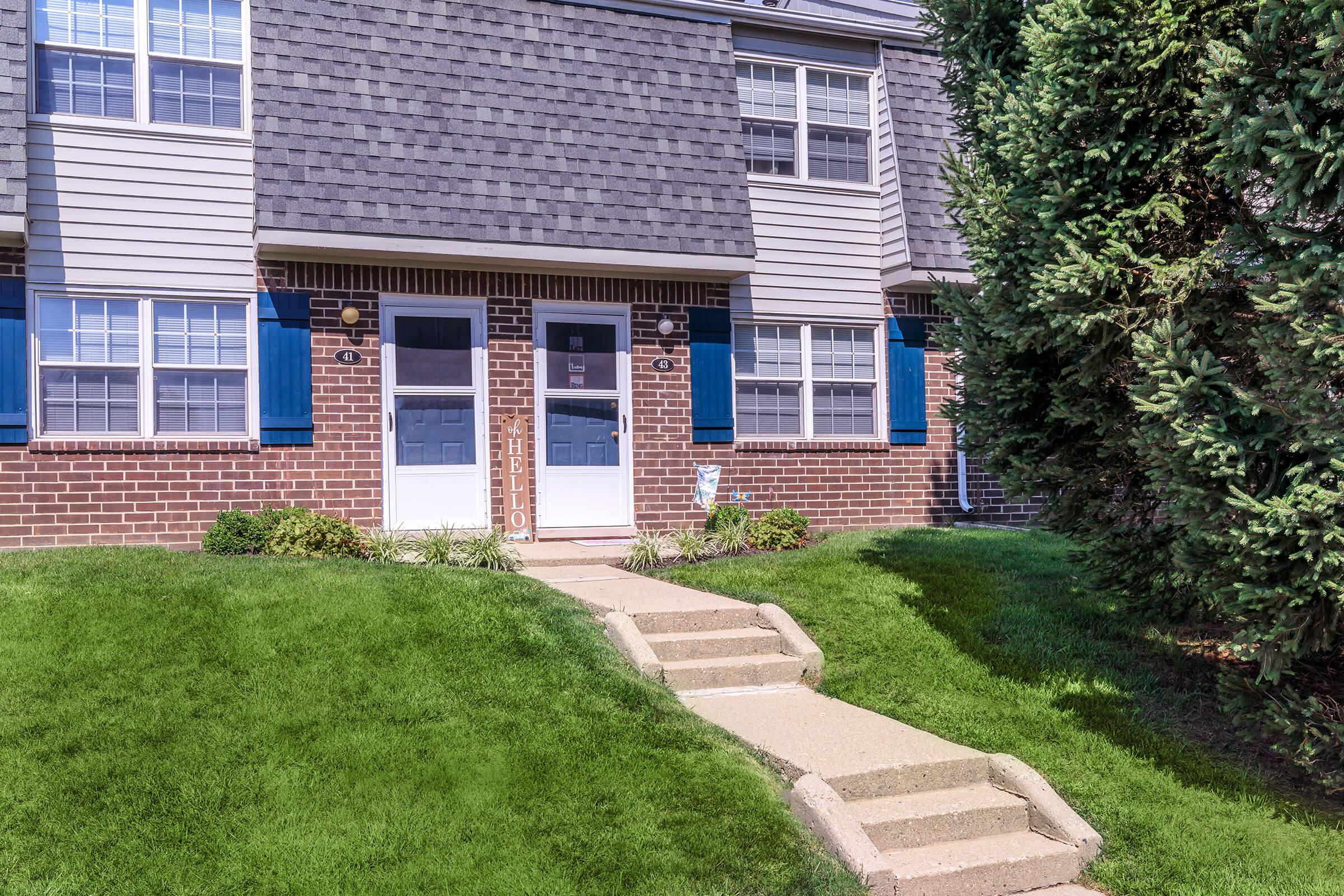 a house with bushes in front of a brick building