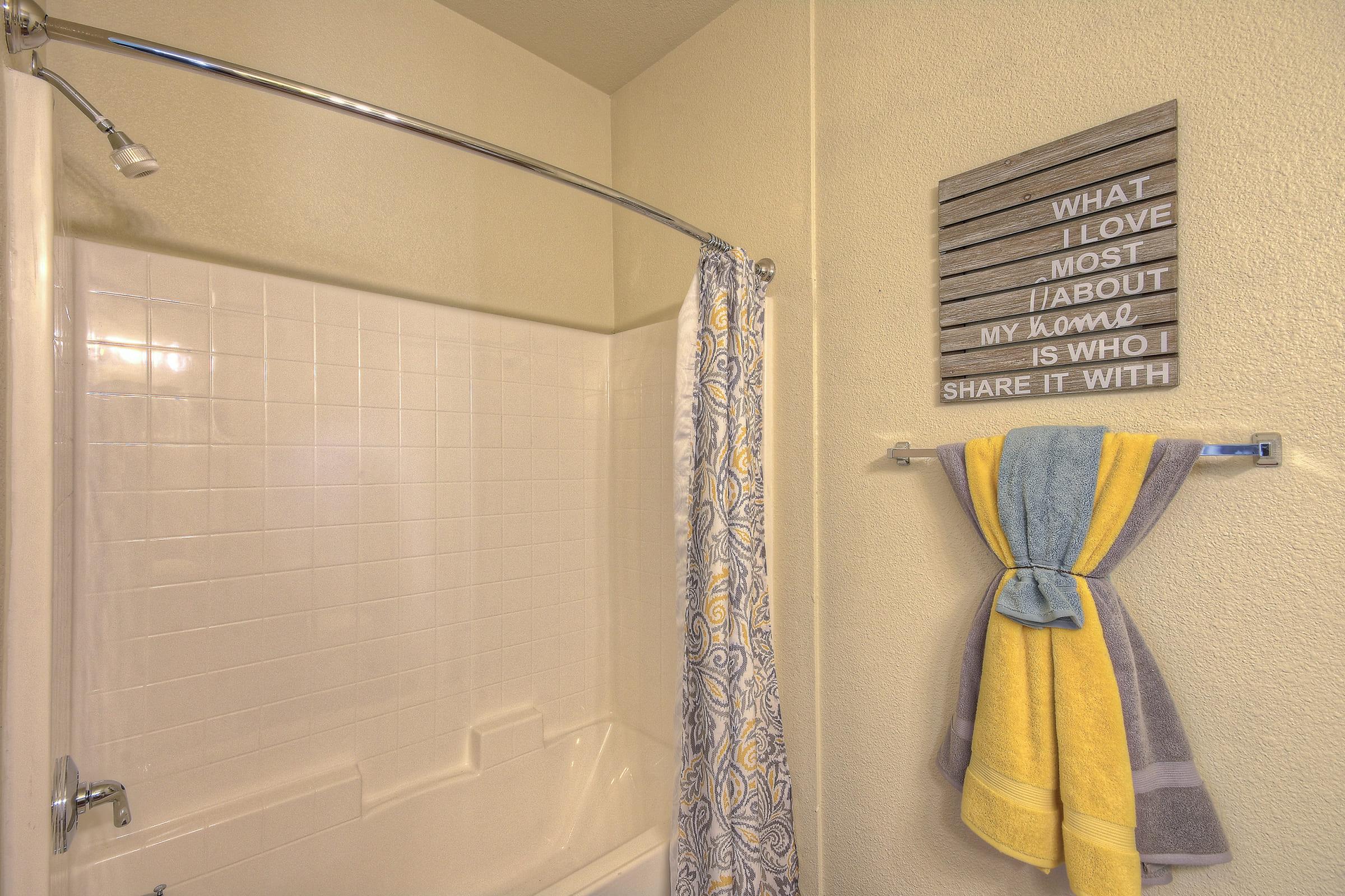 A clean bathroom featuring a shower curtain with a blue and yellow pattern