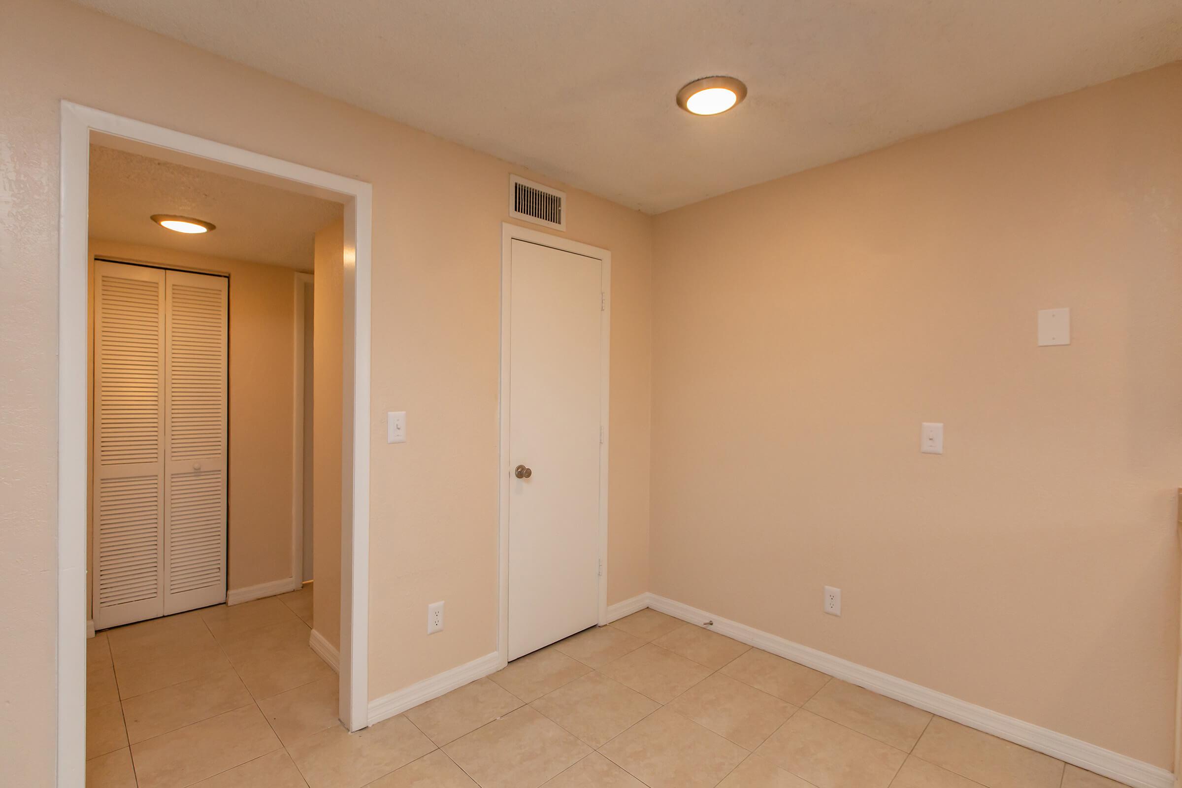 a large empty room with a sink and a mirror