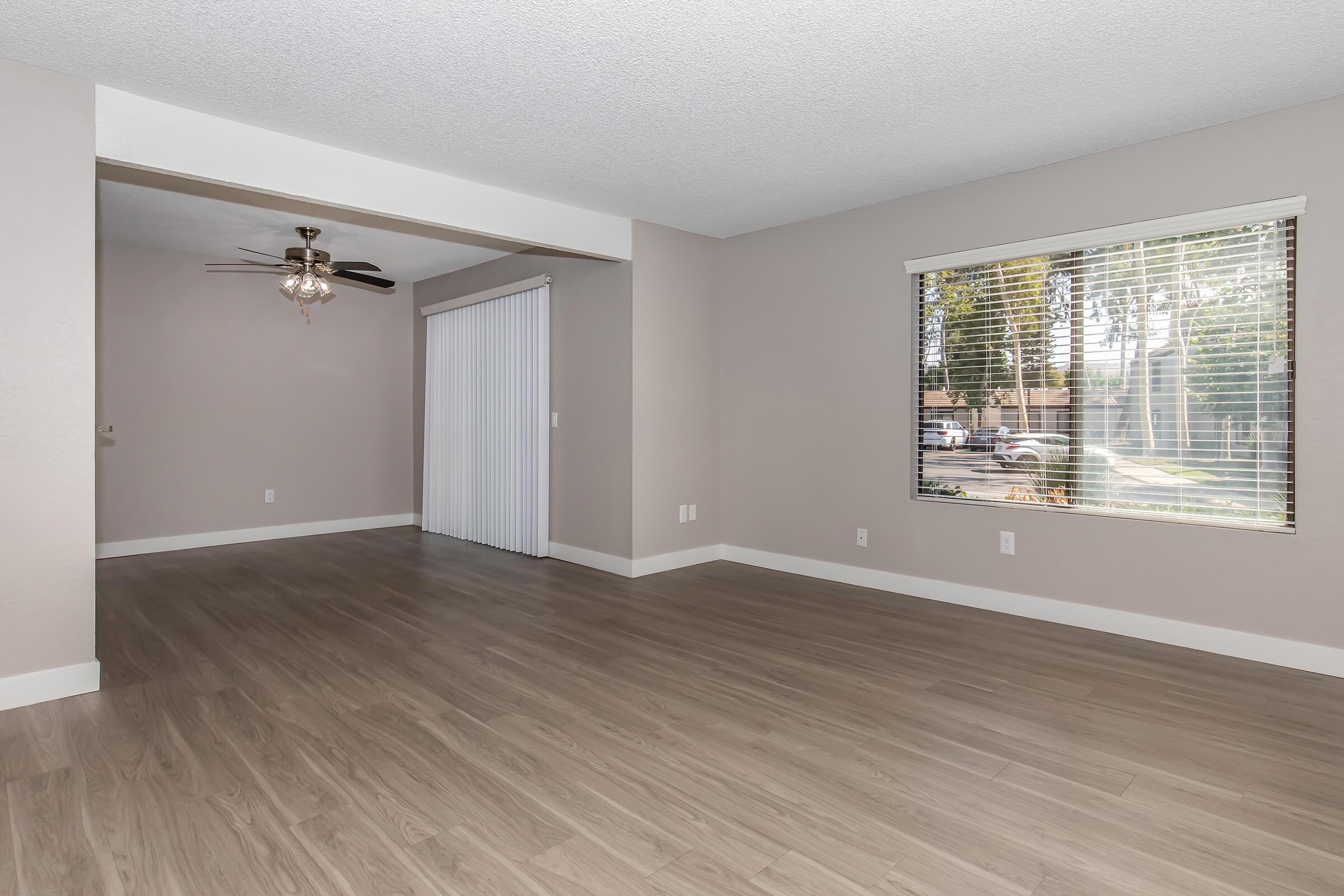 3-Bedroom Apartments in Riverside, CA - Syamore Canyons - Living Room with Hardwood-Style Flooring, a Large window, and a Ceiling Fan