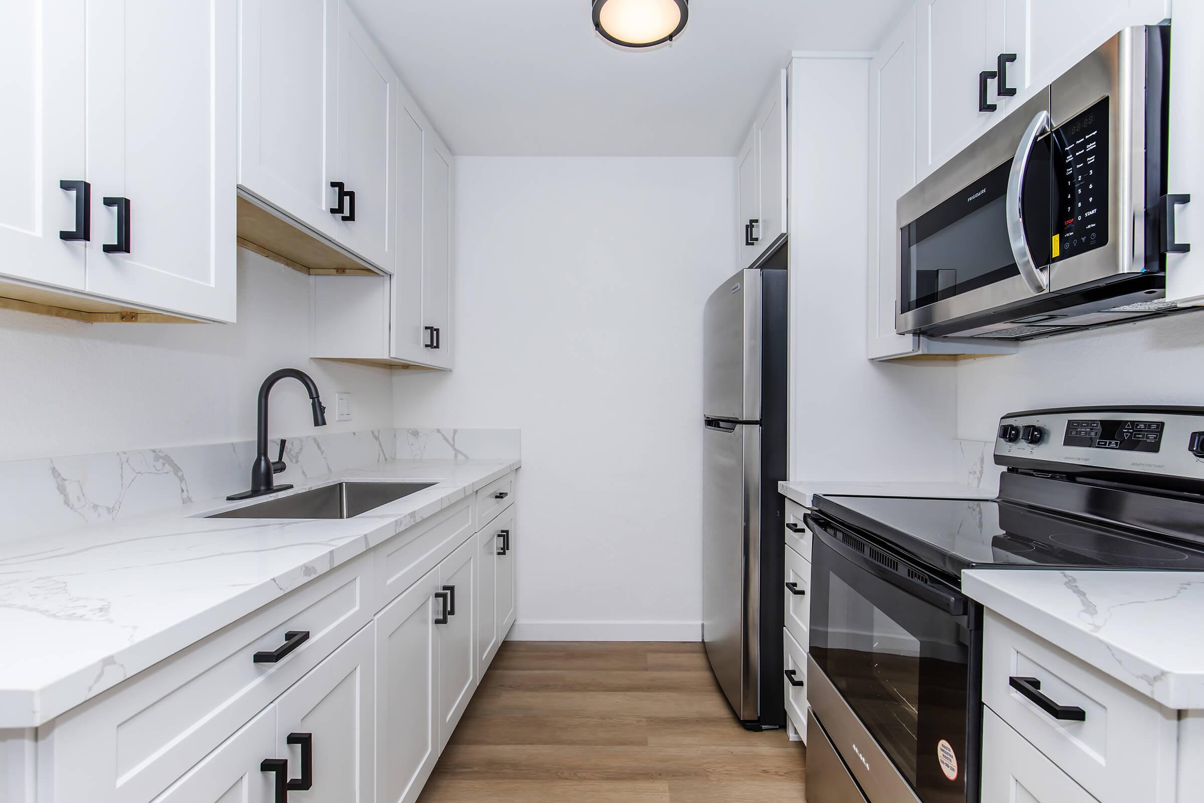 a kitchen with a stove a sink and a microwave