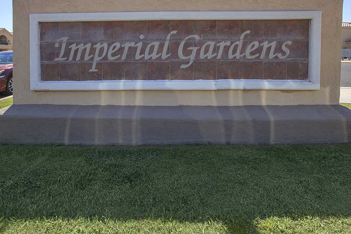 Sign for "Imperial Gardens" featuring stylized lettering against a textured background.