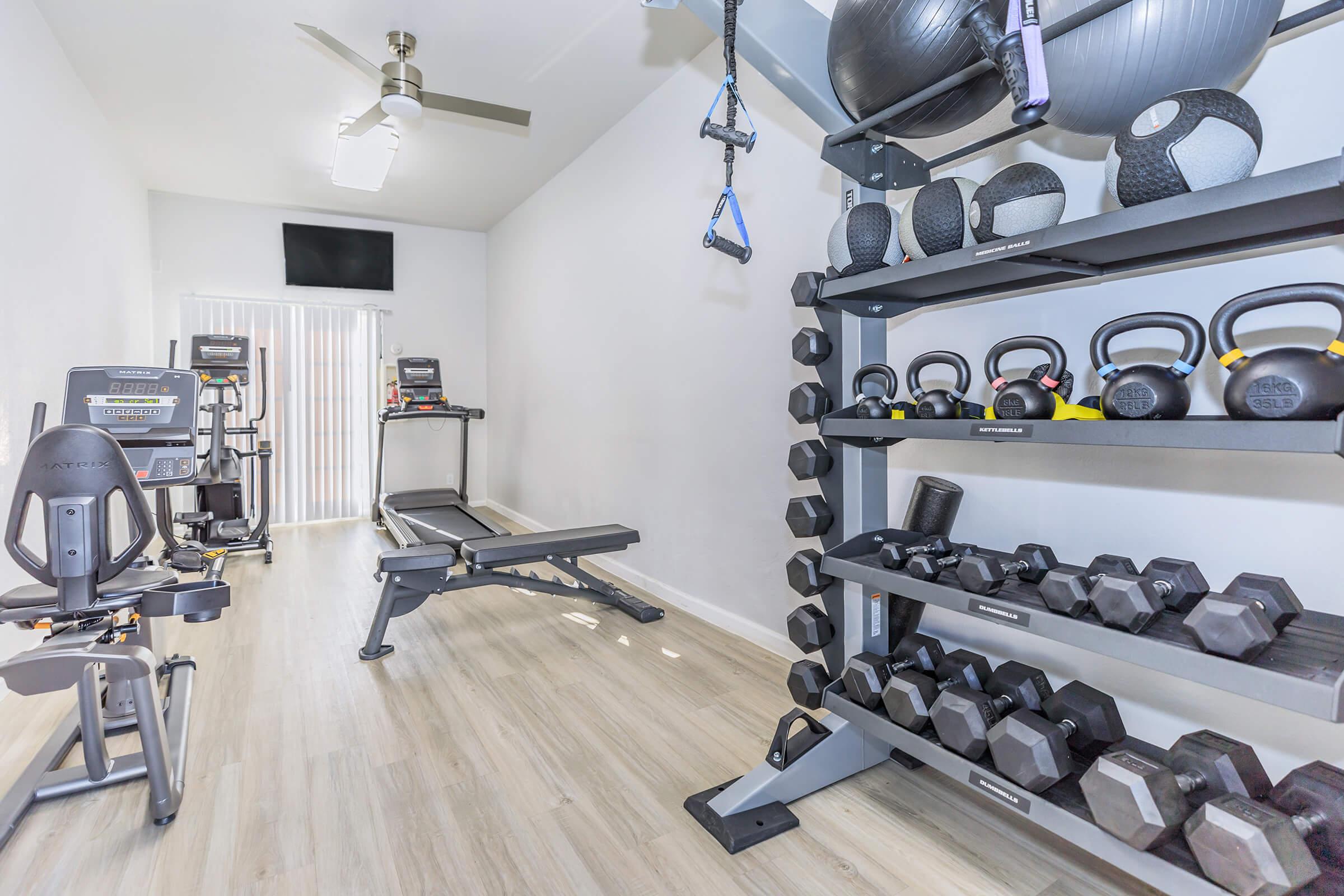 A small fitness room with equipment and a TV at Rise Thunderbird. 