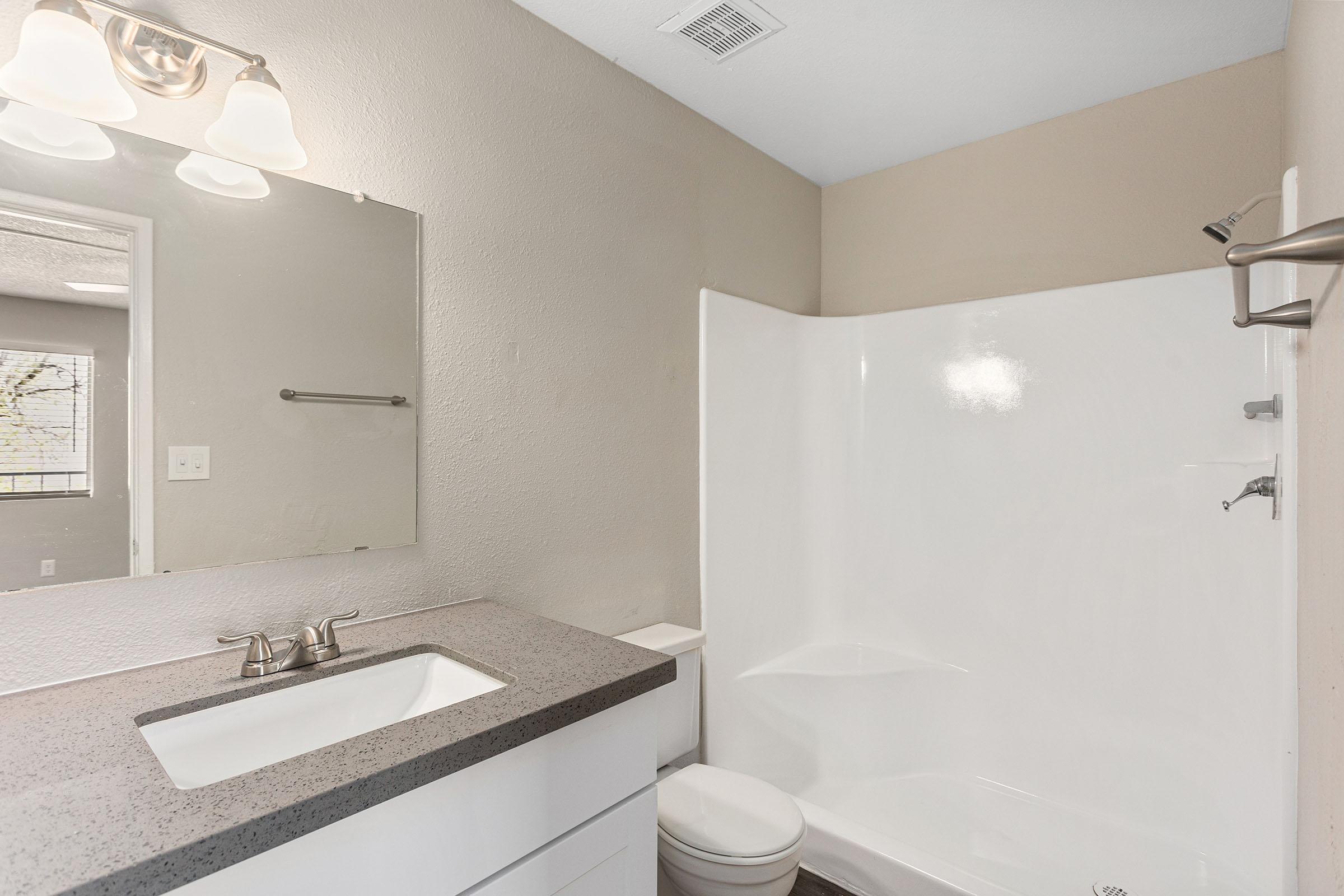 A bathroom with a tub and quartz vanity at Rise Thunderbird.