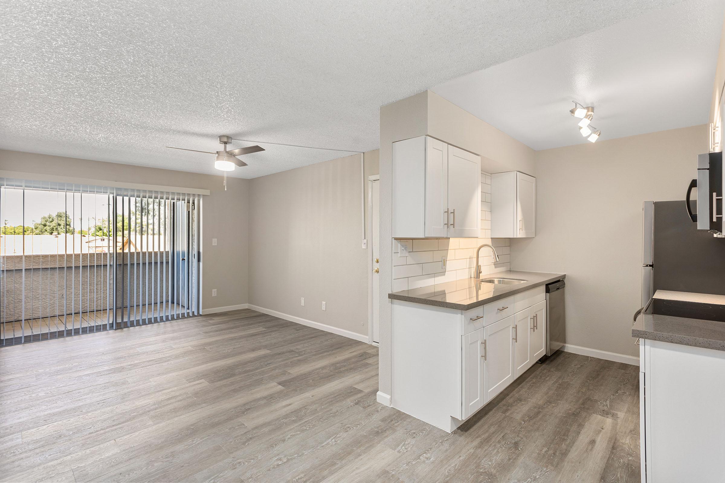 The open-concept living space with wood-style flooring and a large balcony at Rise Thunderbird. 