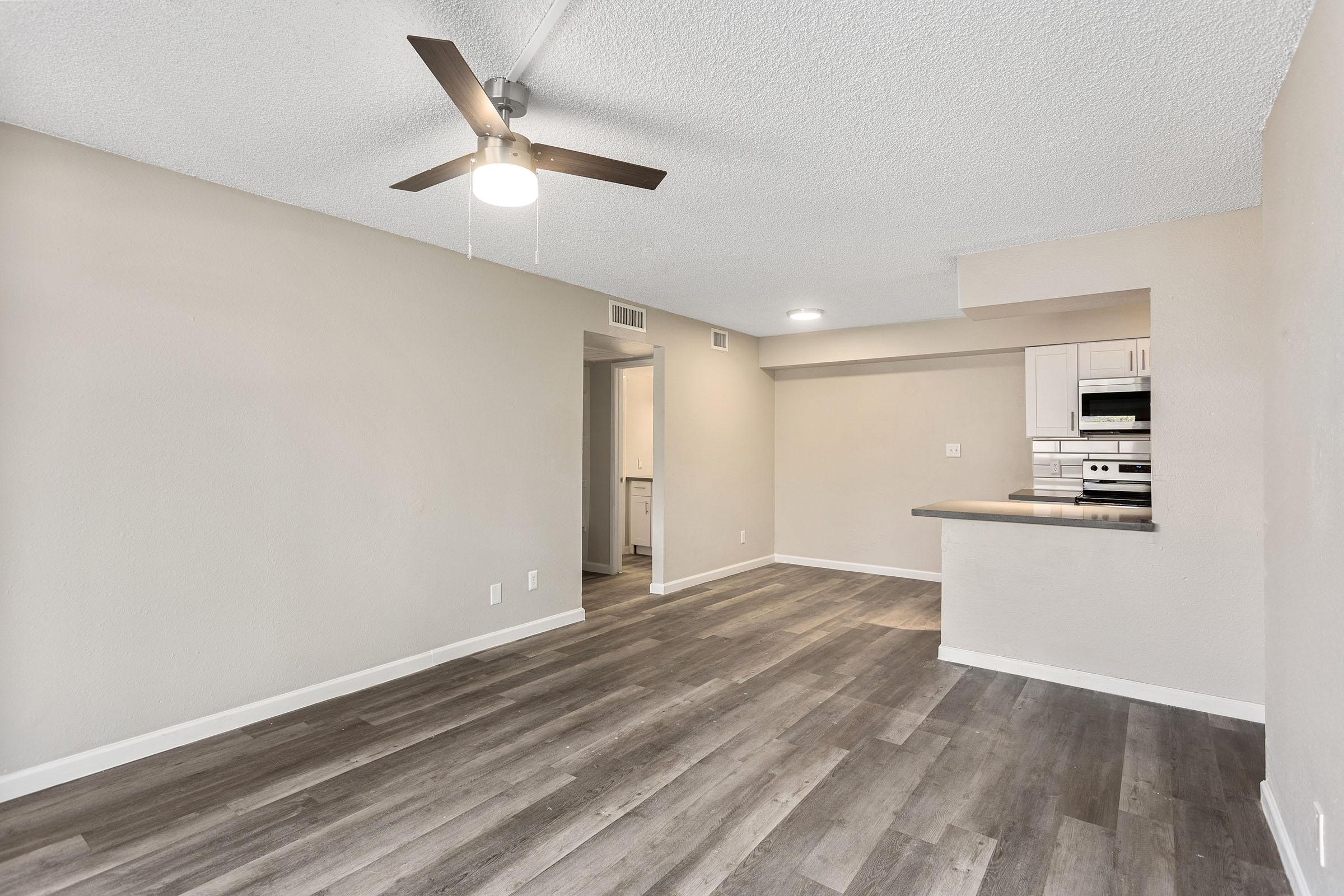 An open-concept living space with a dining area and a kitchen at Rise Thunderbird.