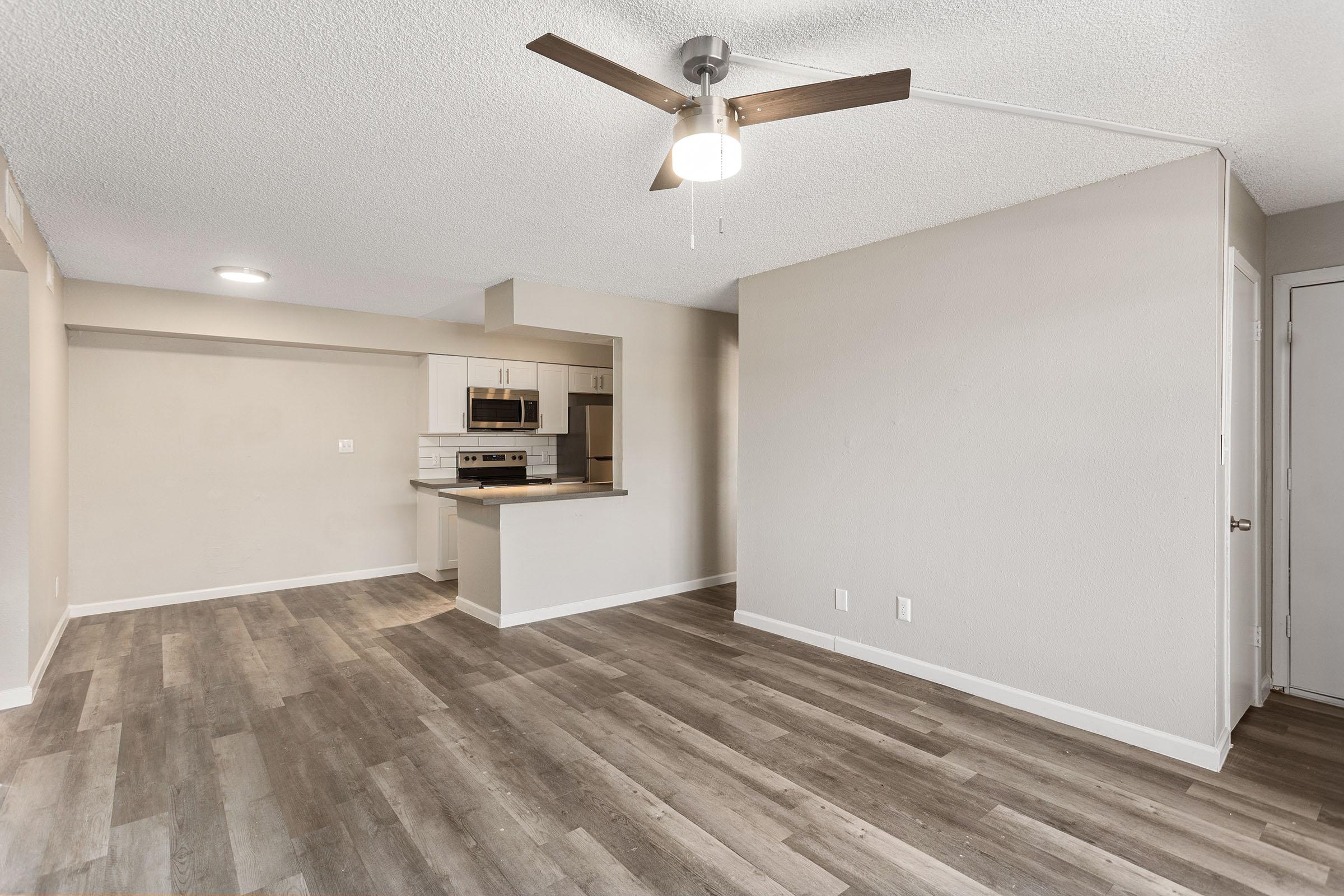 The kitchen, dining and living space with wood-style flooring at Rise Thunderbird. 