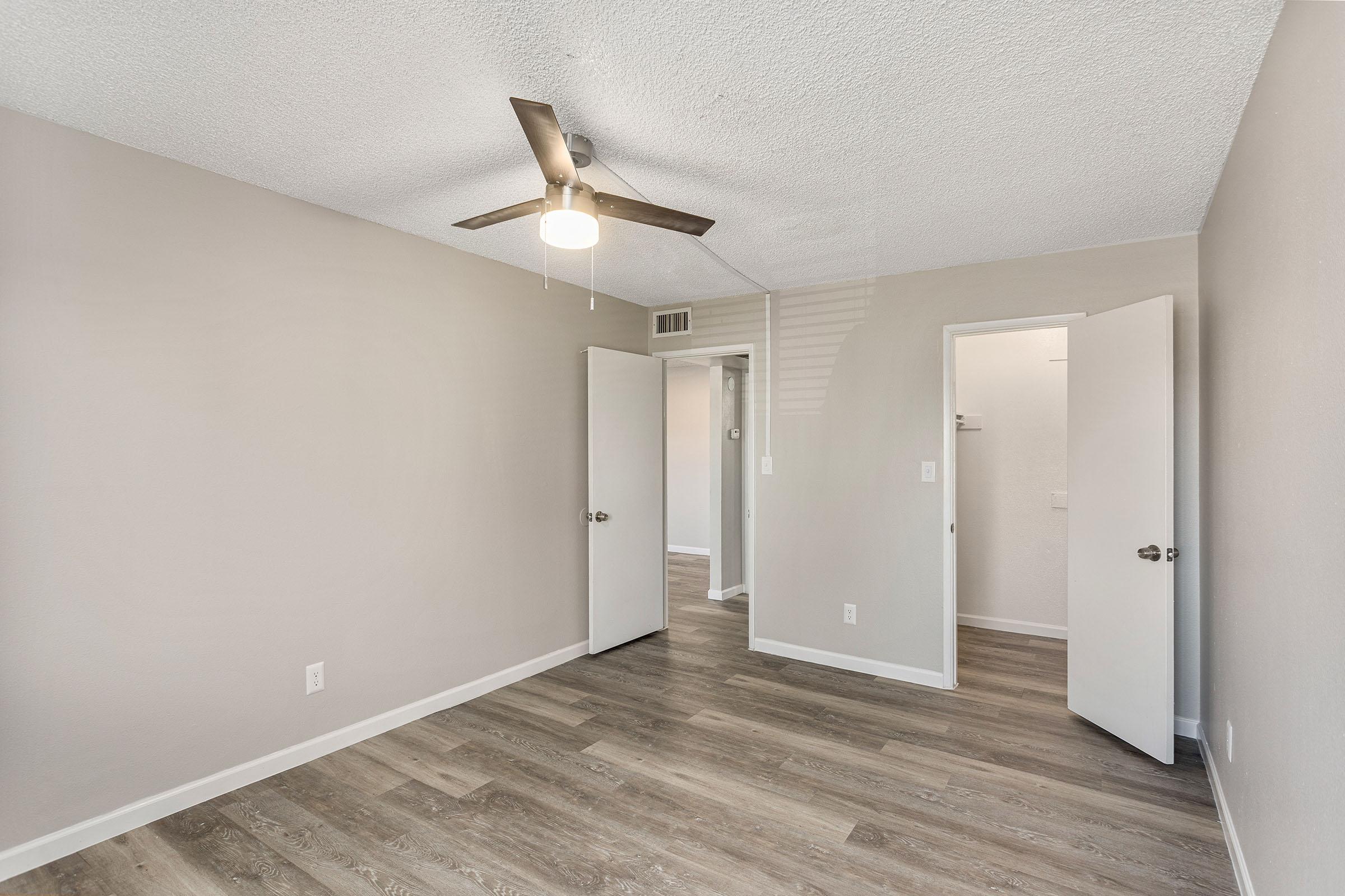 A bedroom with a walk-in closet at Rise Thunderbird. 