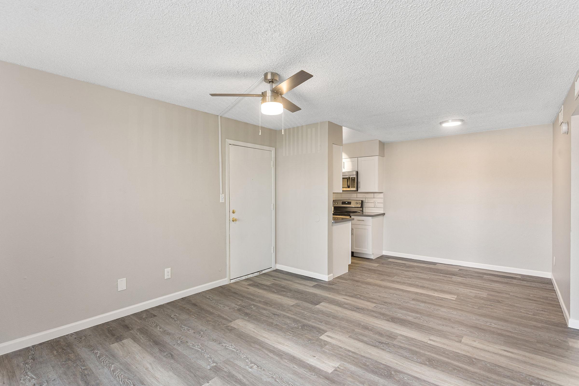 The open-concept living space with wood-style flooring at Rise Thunderbird.