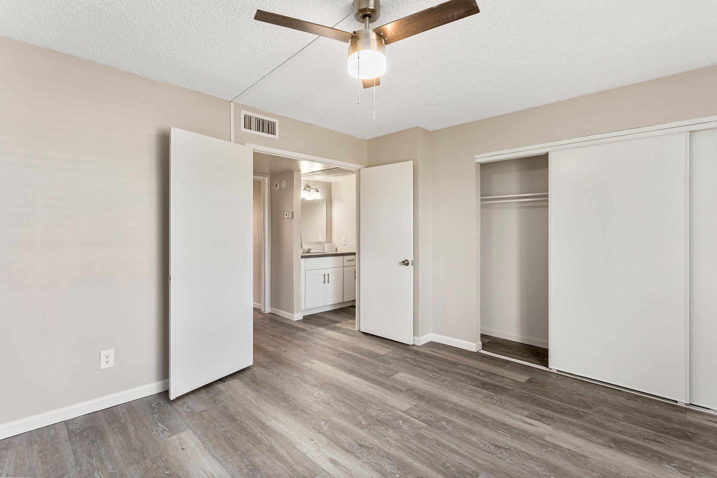 A bedroom with double doors and a bathroom at Rise Thunderbird in Phoenix, AZ. 