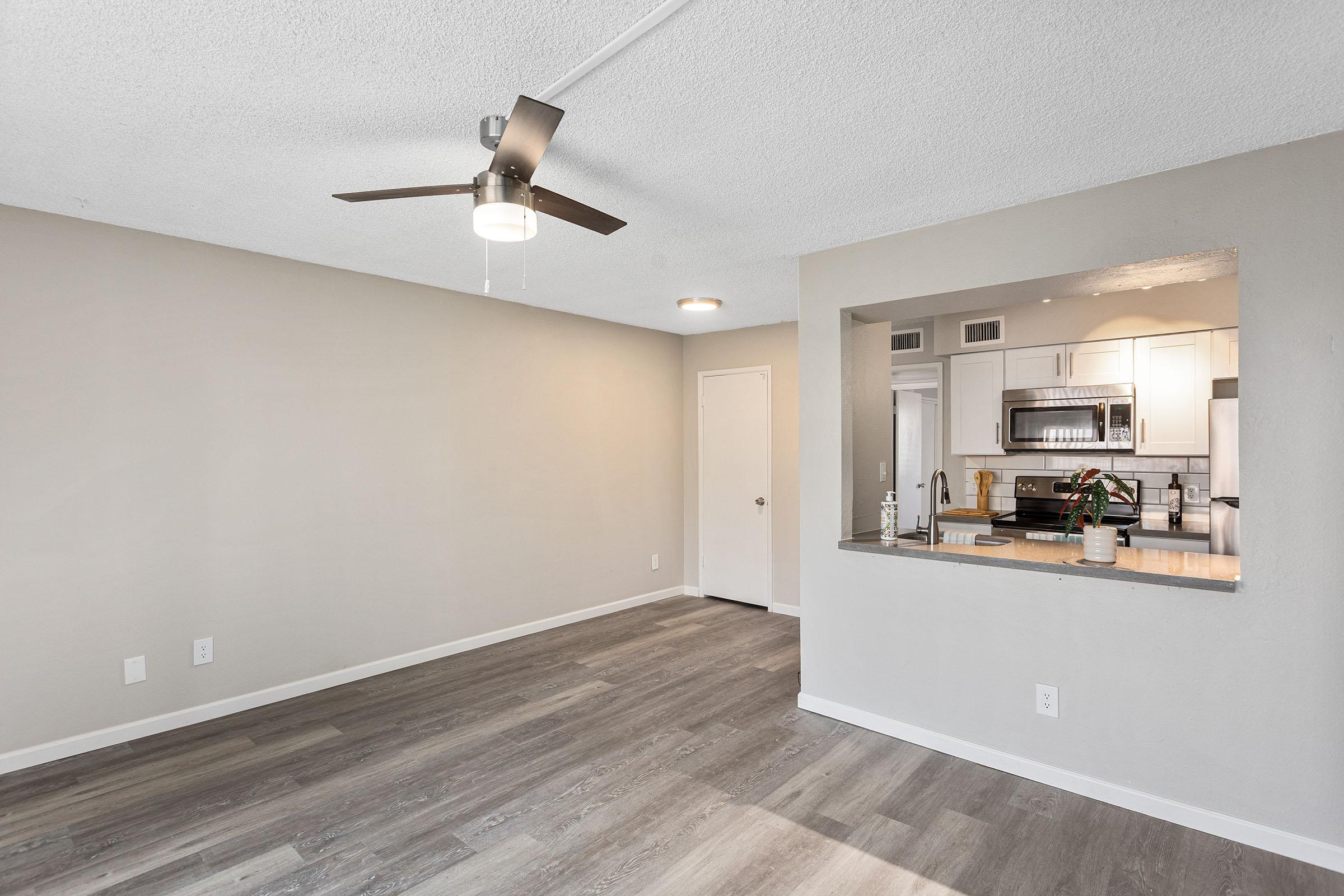 An open-concept living space with a dining area and a kitchen at Rise Thunderbird.