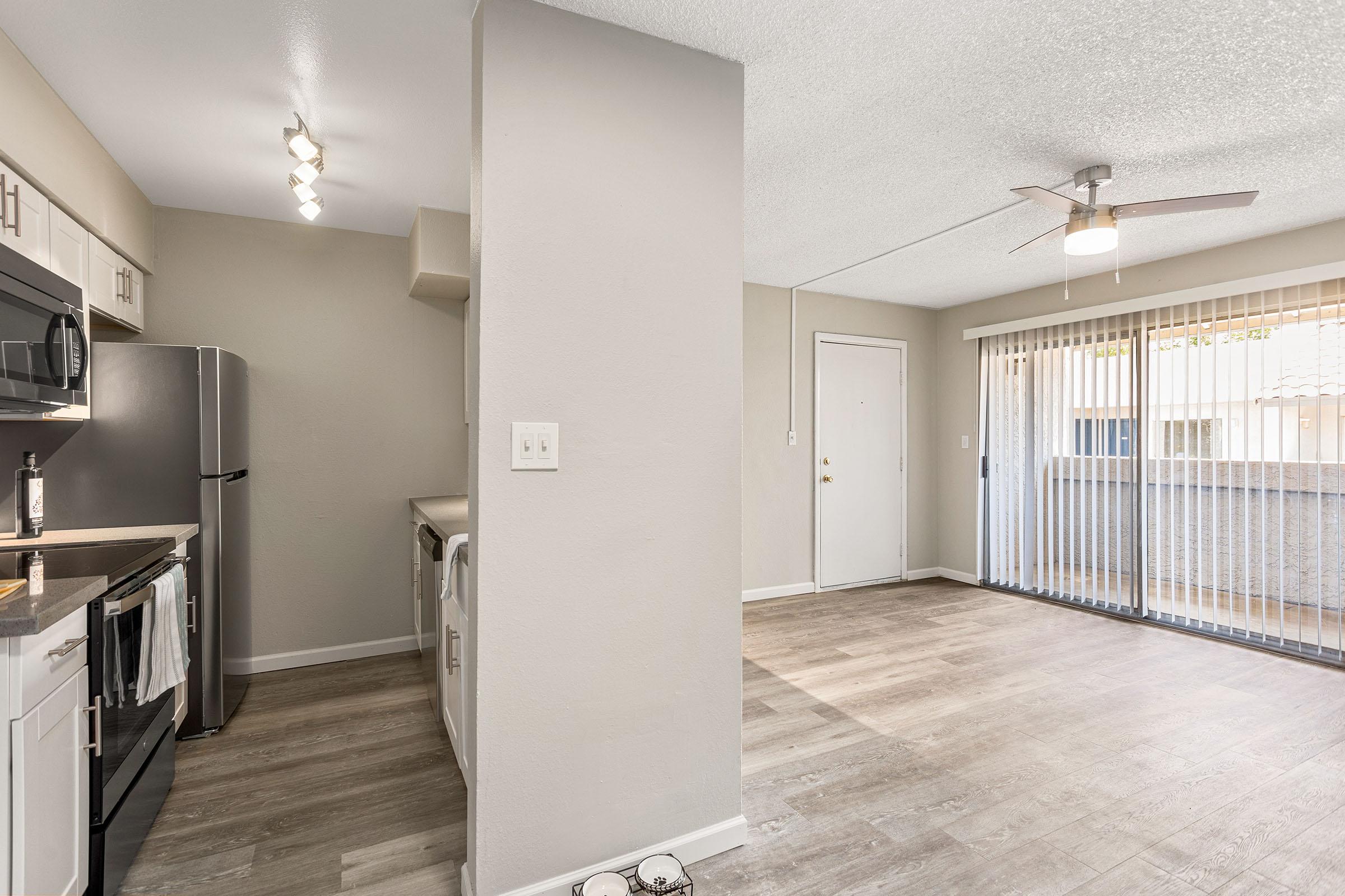 An open-concept apartment with a kitchen, living area and a balcony at Rise Thunderbird. 