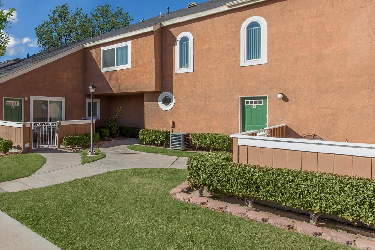 a large brick building with grass in front of a house