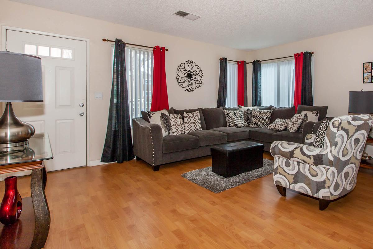 a living room filled with furniture on top of a hard wood floor