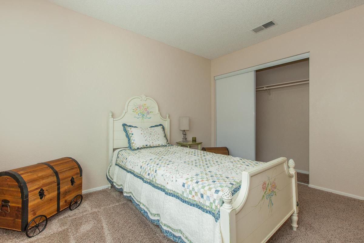 a bedroom with a bed and desk in a small room