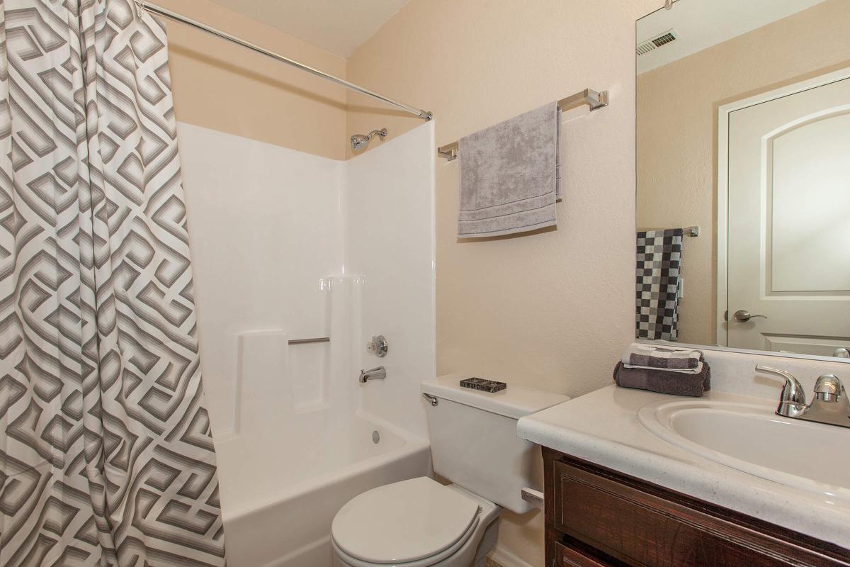 a white sink sitting under a mirror