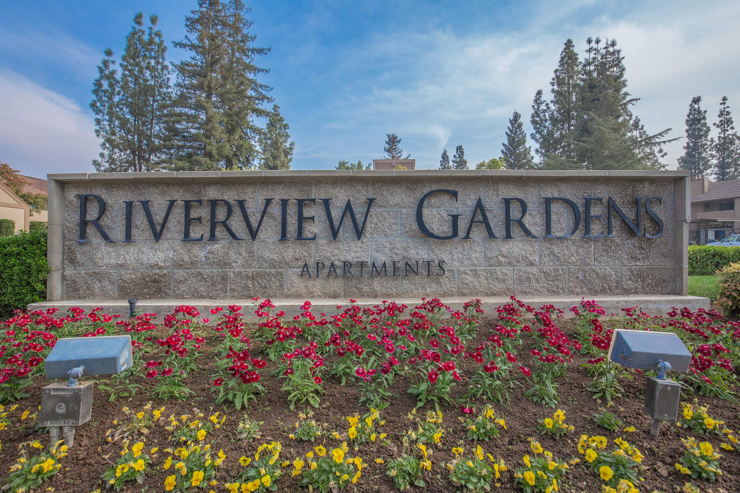 a sign above a flower garden