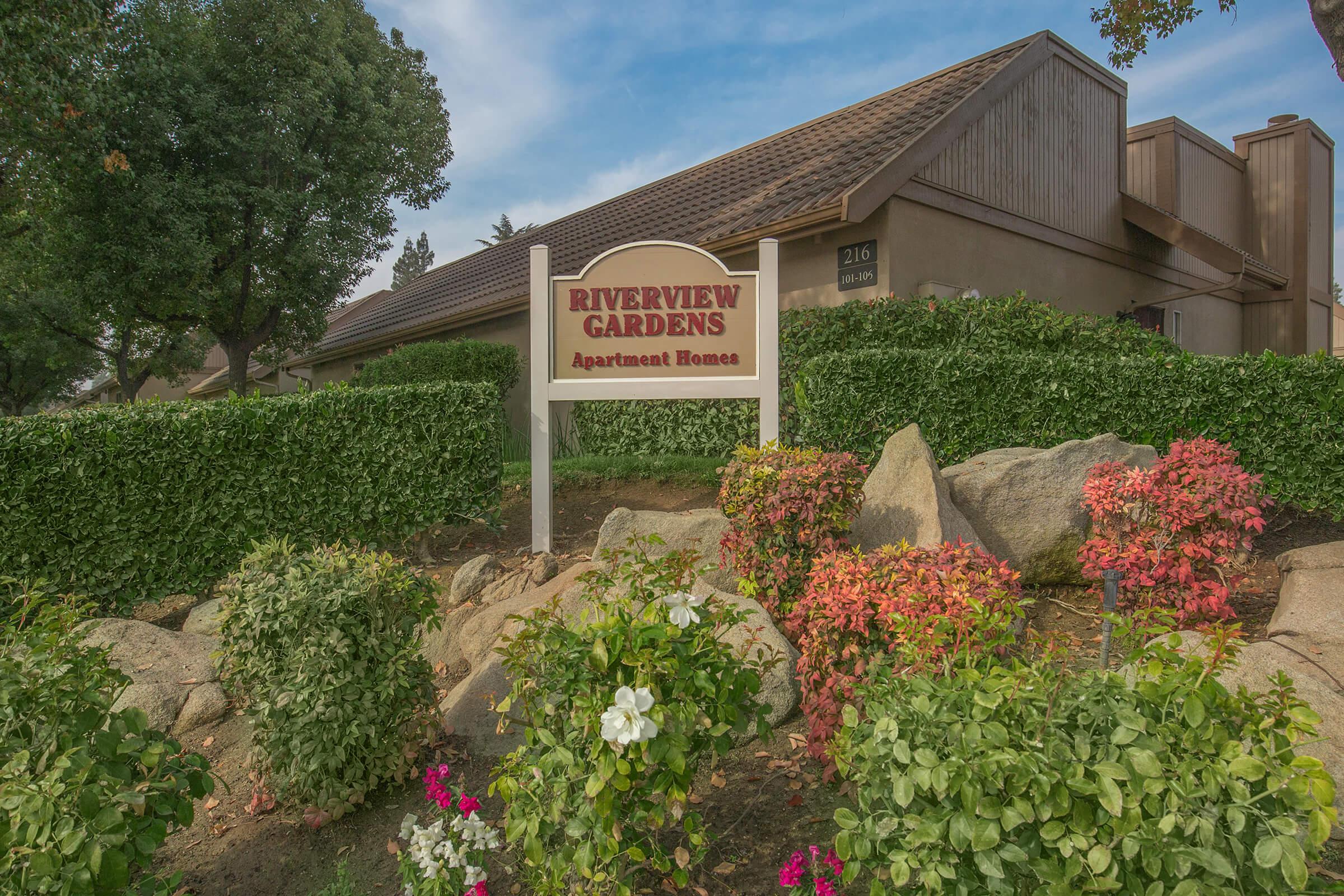 a close up of a flower garden in front of a house