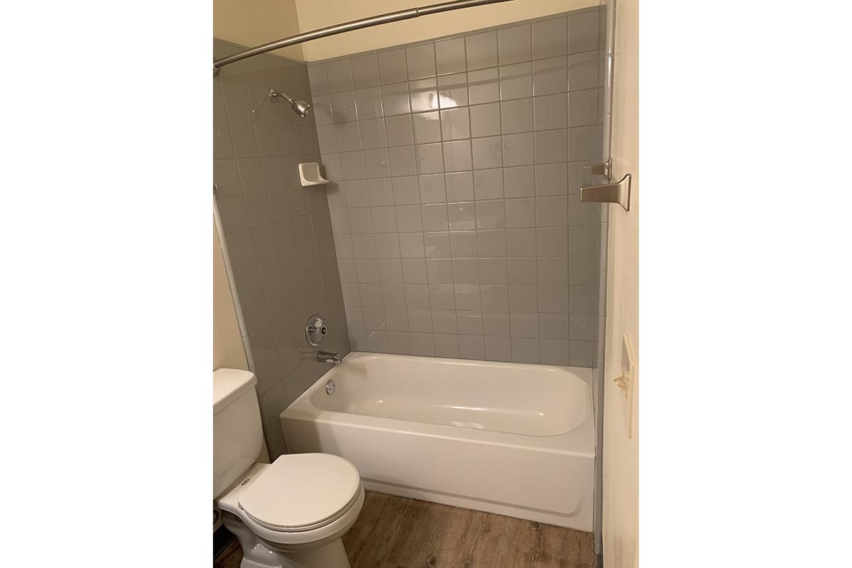 a white sink sitting next to a tiled wall