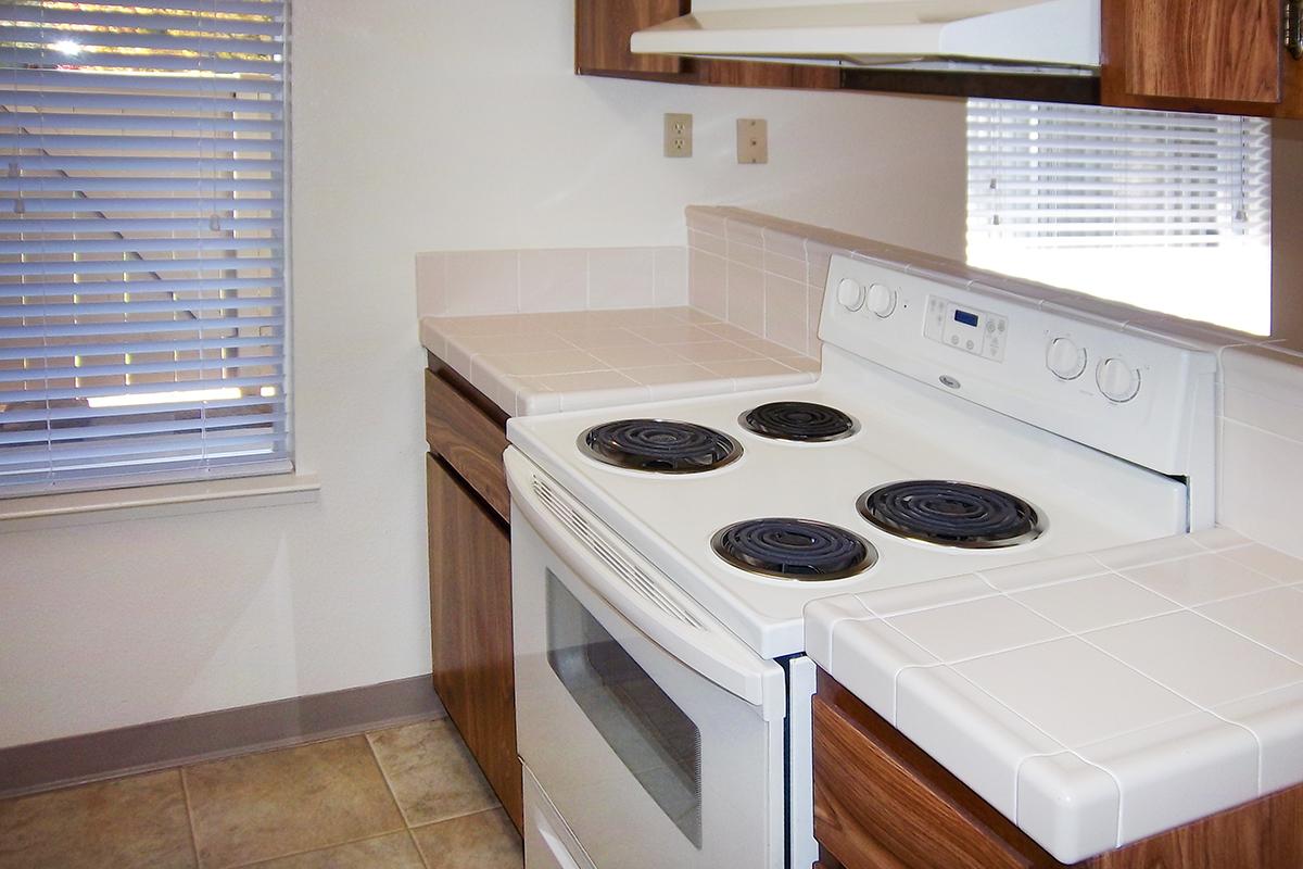 a white stove top oven sitting inside of a kitchen