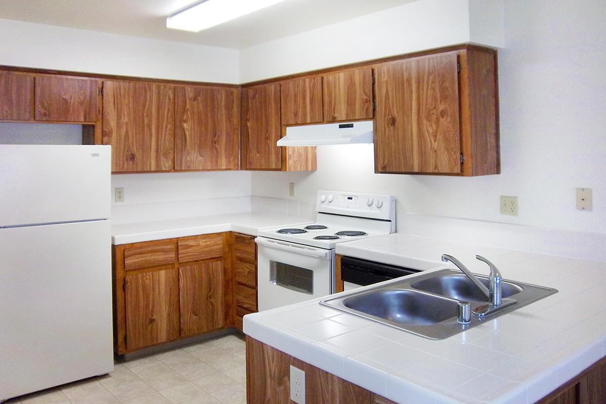 a kitchen with white appliances and wooden cabinets