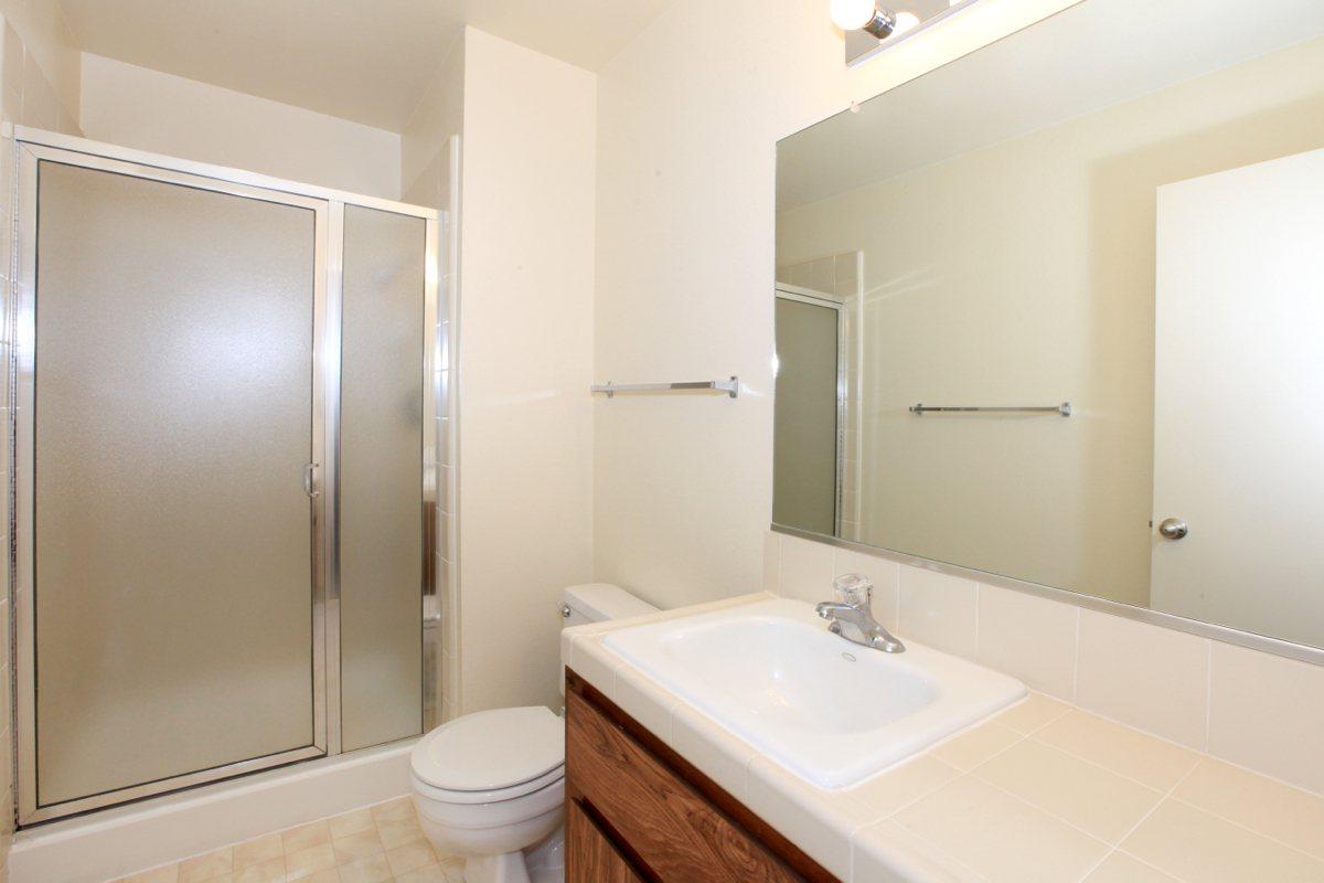 a white sink sitting next to a shower