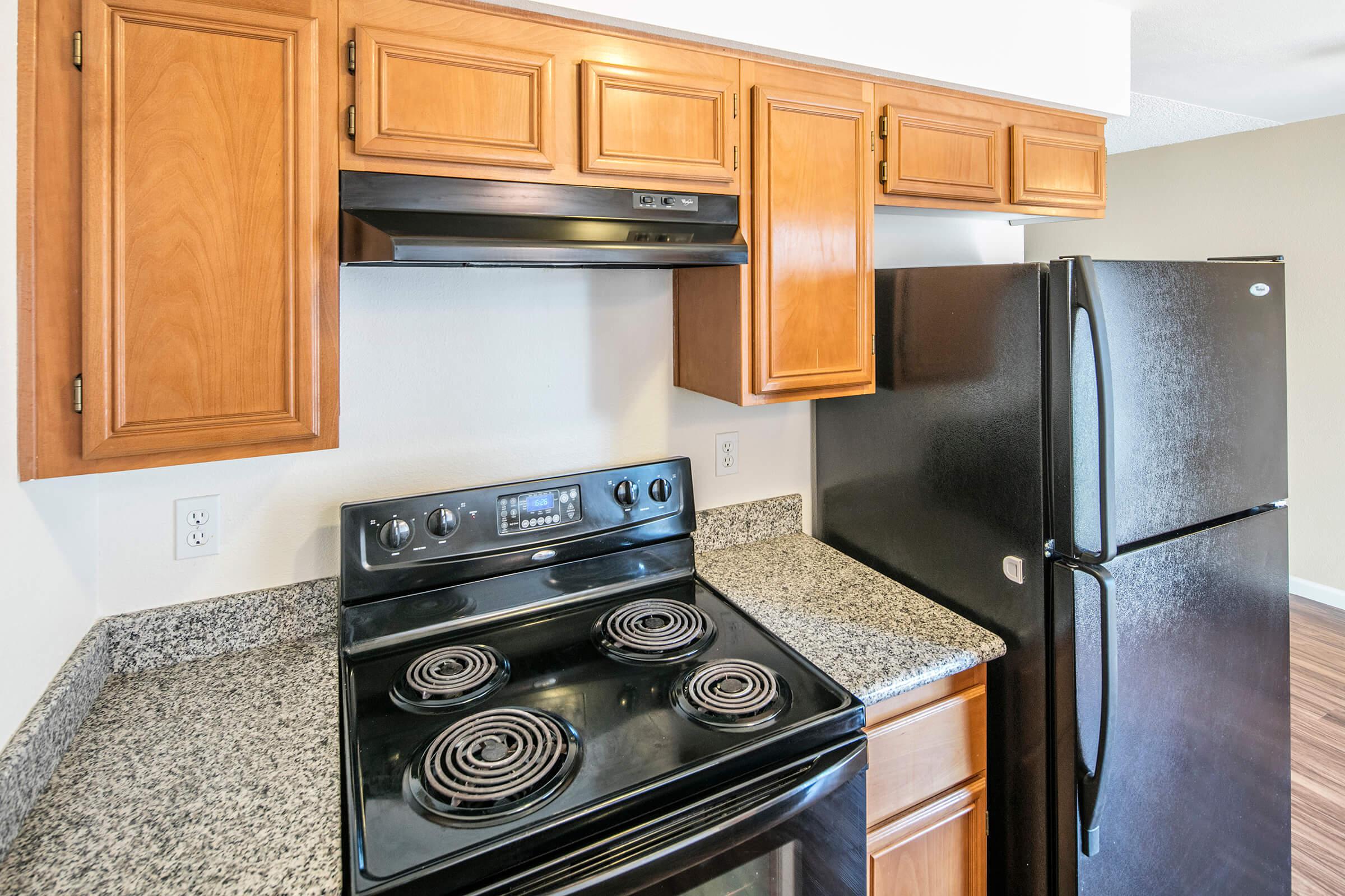 a stove top oven sitting inside of a kitchen with stainless steel appliances