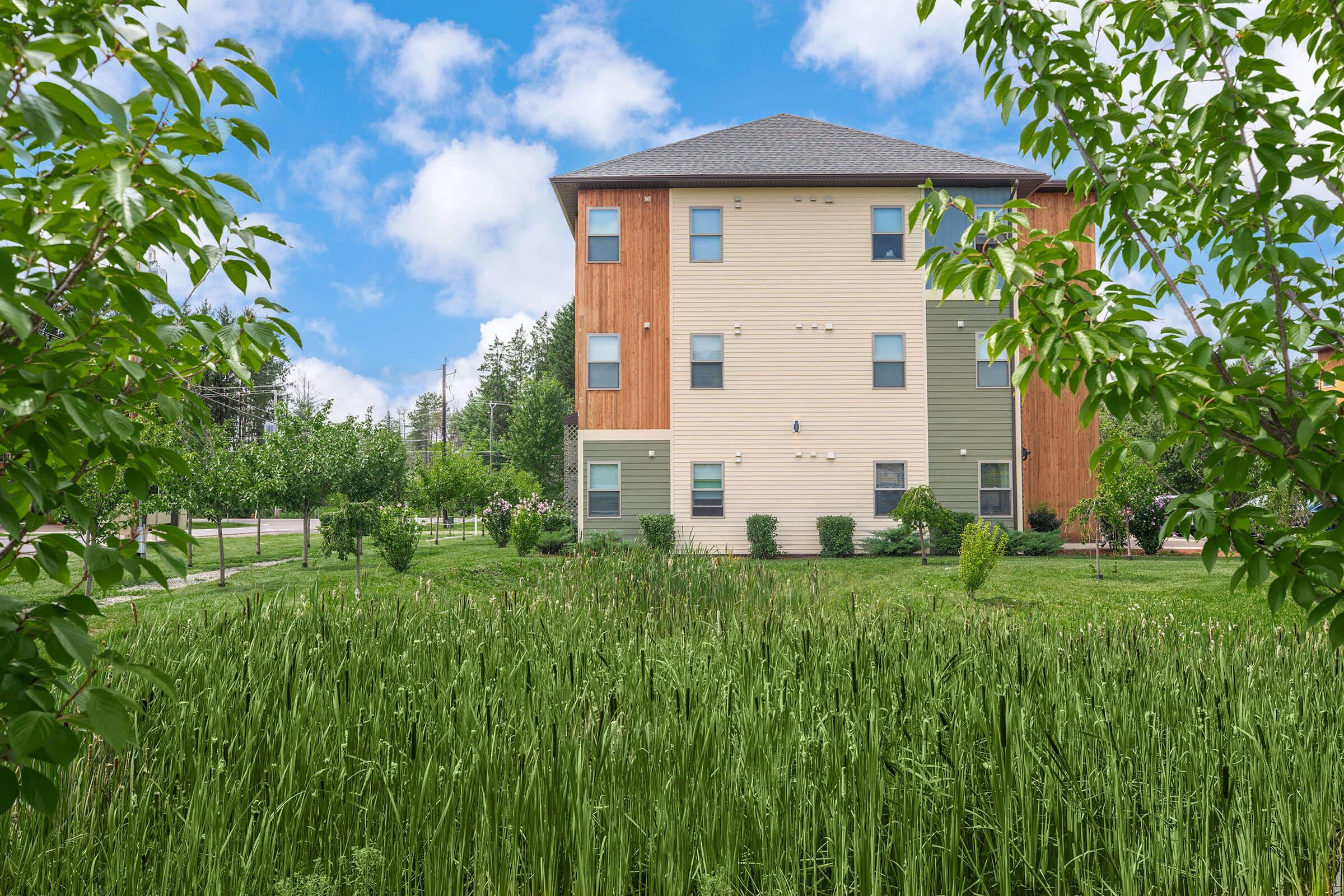 a large green field in front of a house