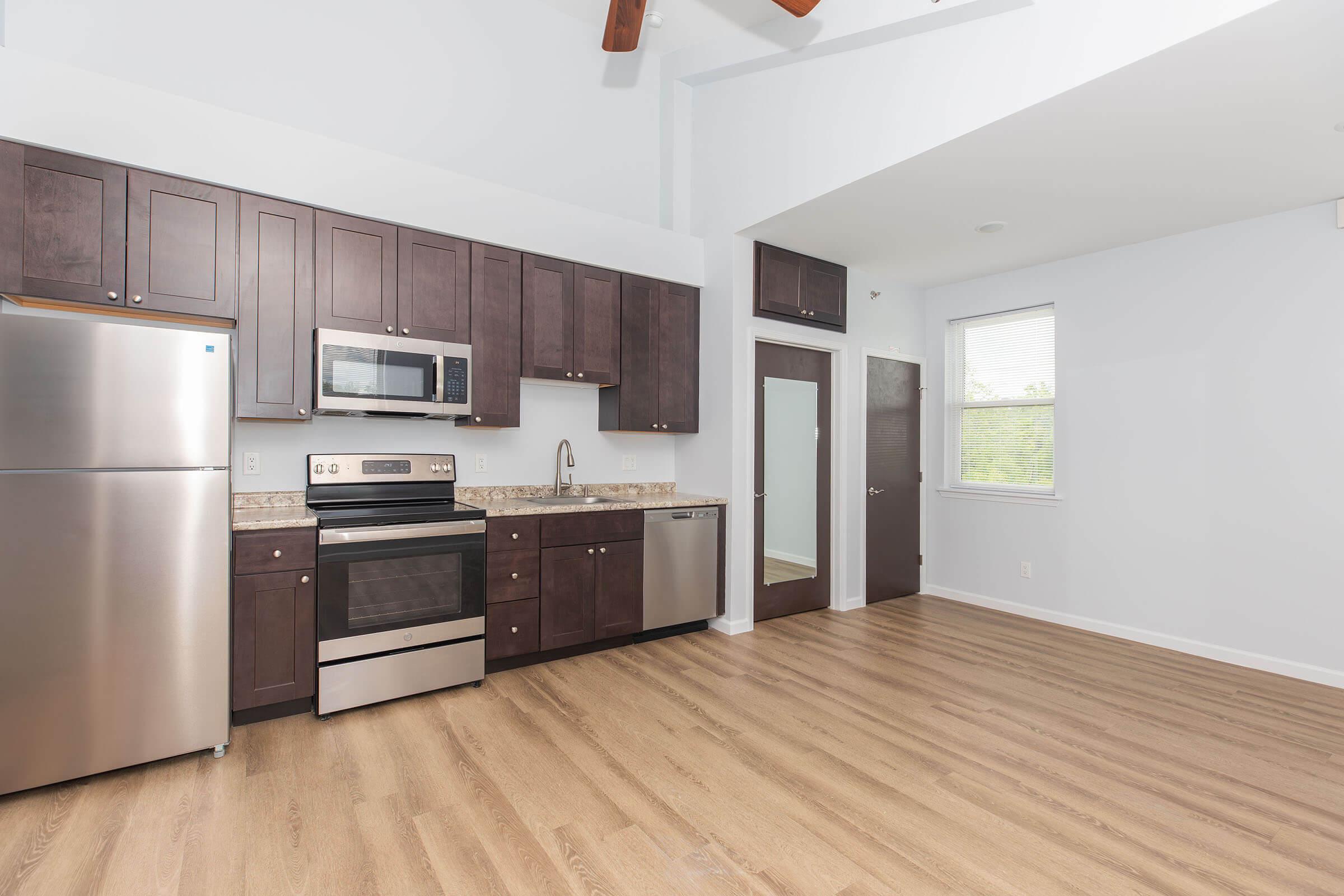 a large kitchen with stainless steel appliances and wooden cabinets