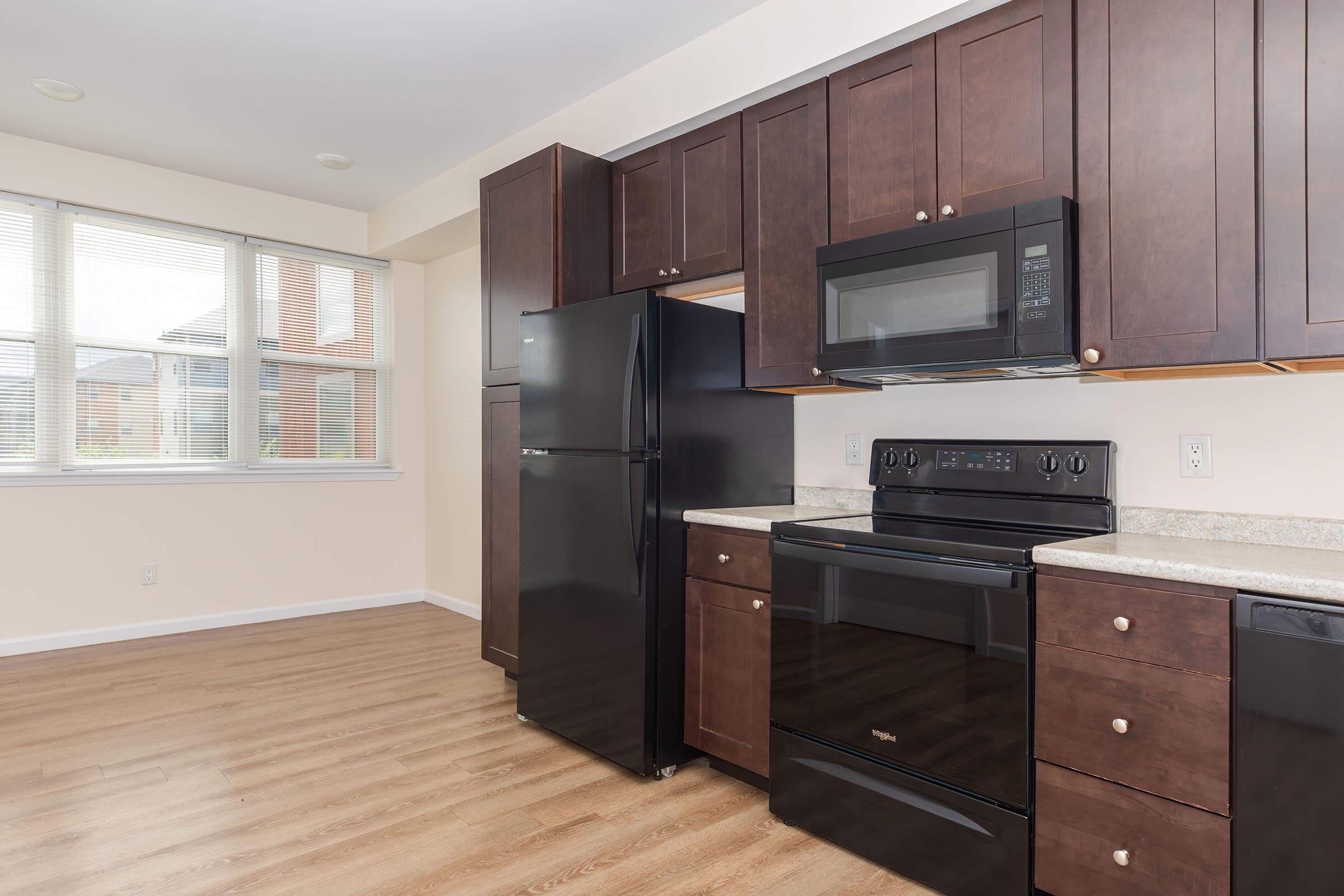 a large kitchen with stainless steel appliances and wooden cabinets