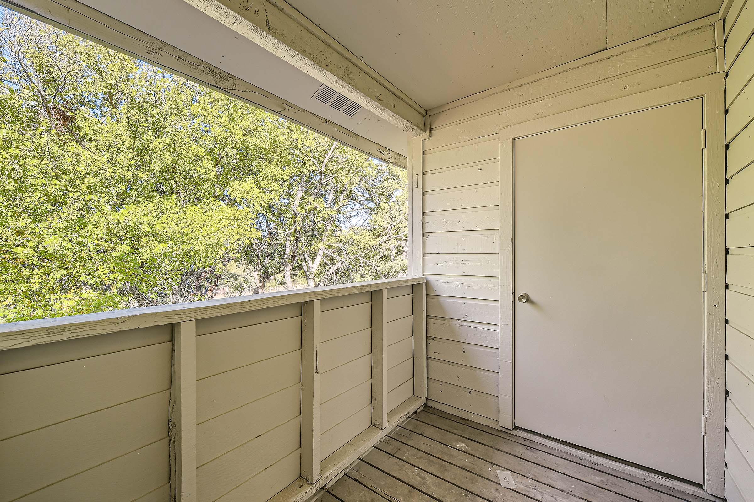 Outdoor apartment covered balcony with a view of the trees at Rise Bedford Lake