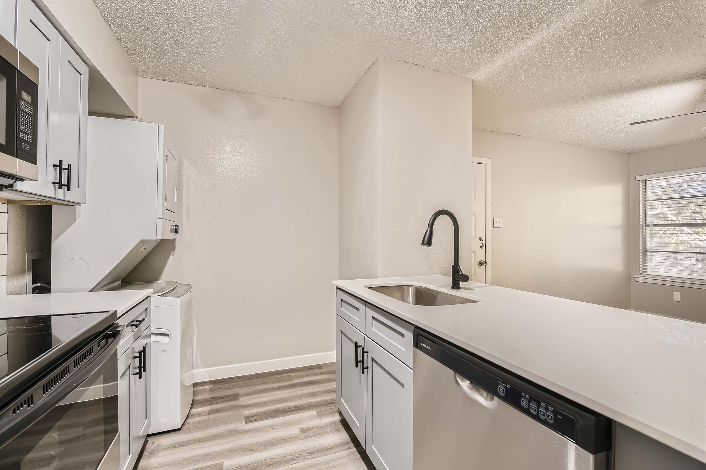Rise Bedford Lake apartment kitchen with stove, microwave, sink, dishwasher, and washer/dryer
